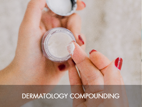 A person with red painted nails is holding a small container of dermatology compound and scooping some with a metal spatula.