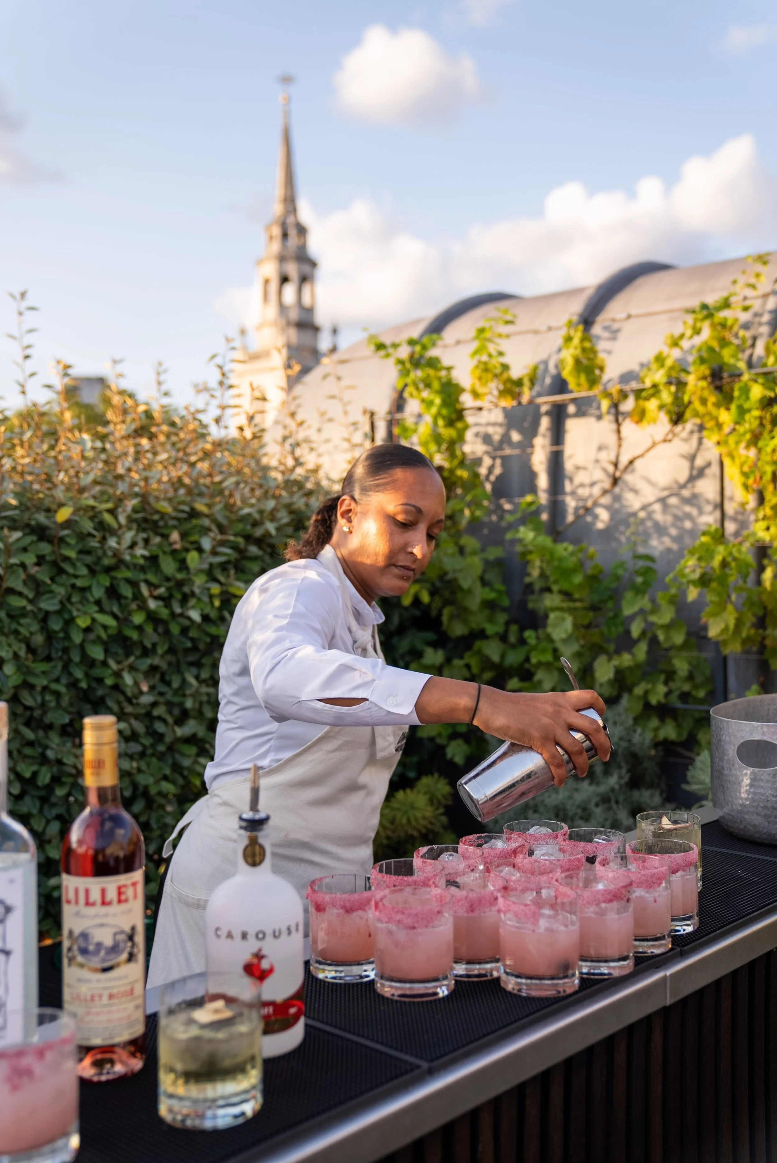 Outside bar with member of staff serving cocktails