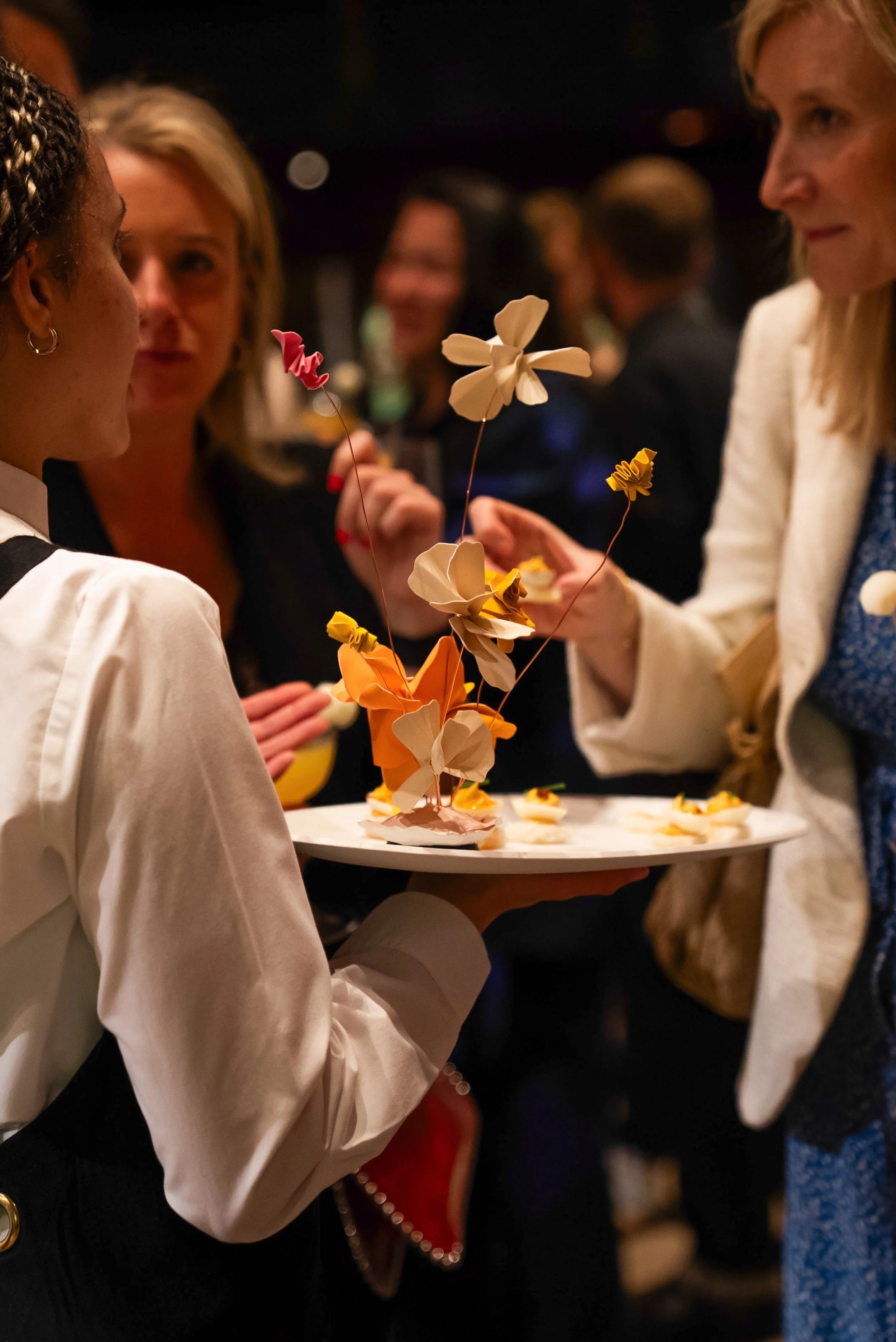 Guests taking canapes from a tray at an event