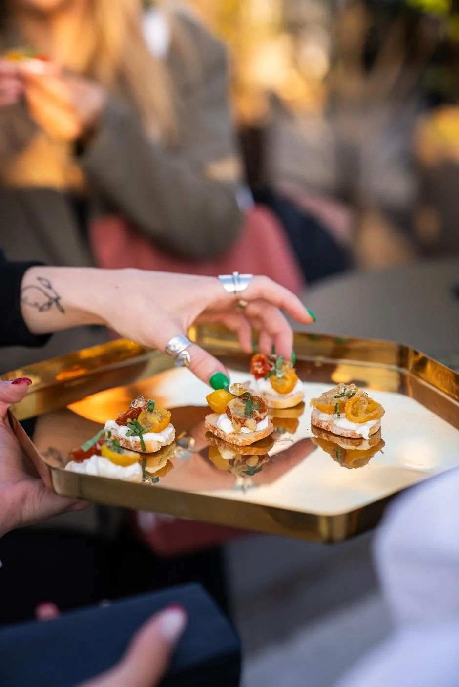 Guest helping themselves to canapes being tray served by a member of the team