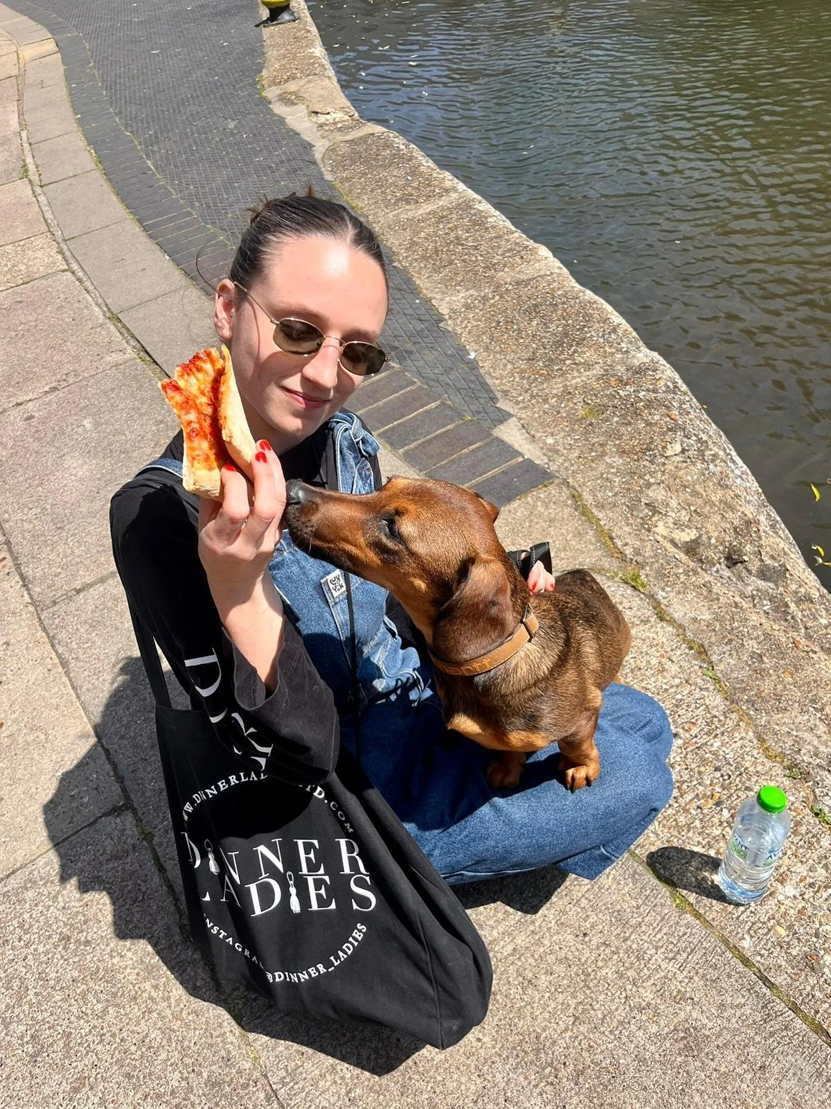 Zoe with her pet dog enjoying pizza