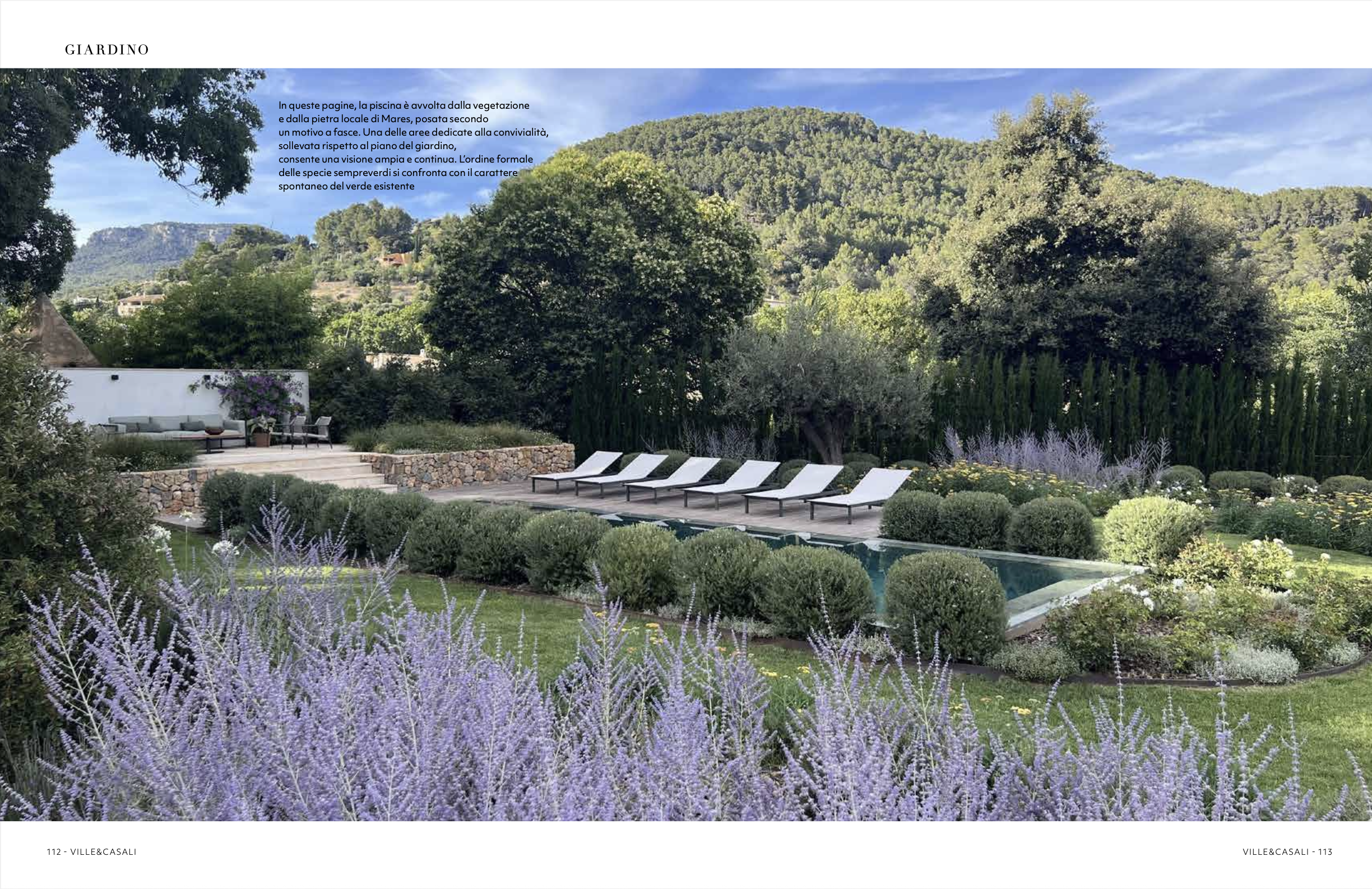Mares stone terrace and steps leading to pool with bambu deck and sun loungers surrounded by Mediterranean garden