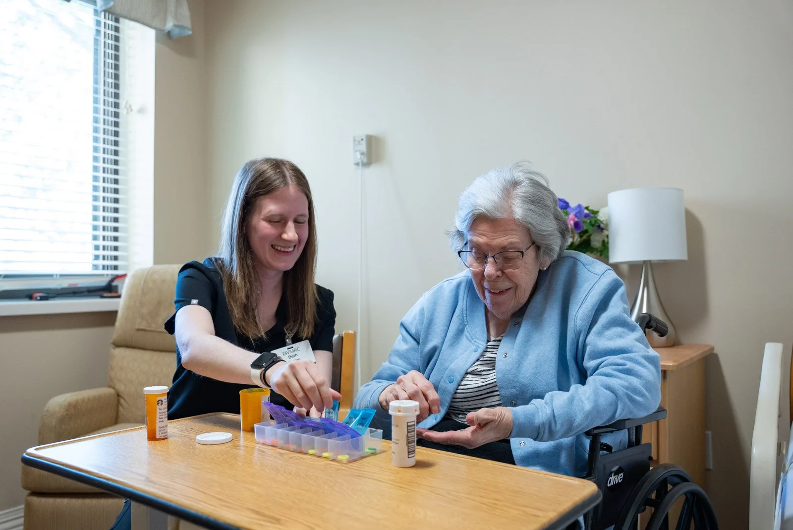 a speech therapist helping her patient sort her medication.