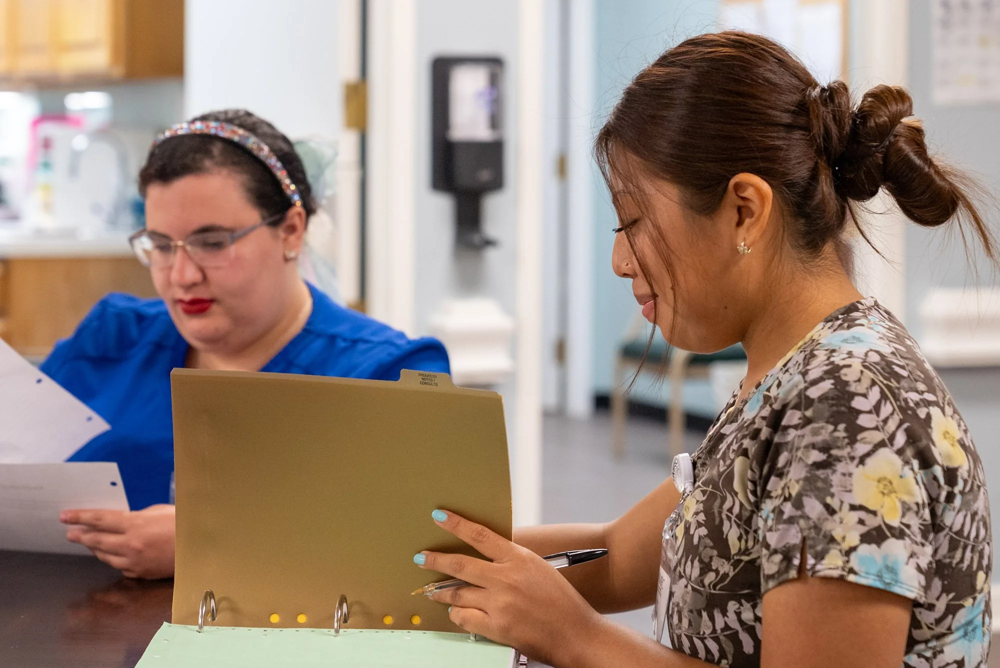 two nurses sitting and looking at charts together