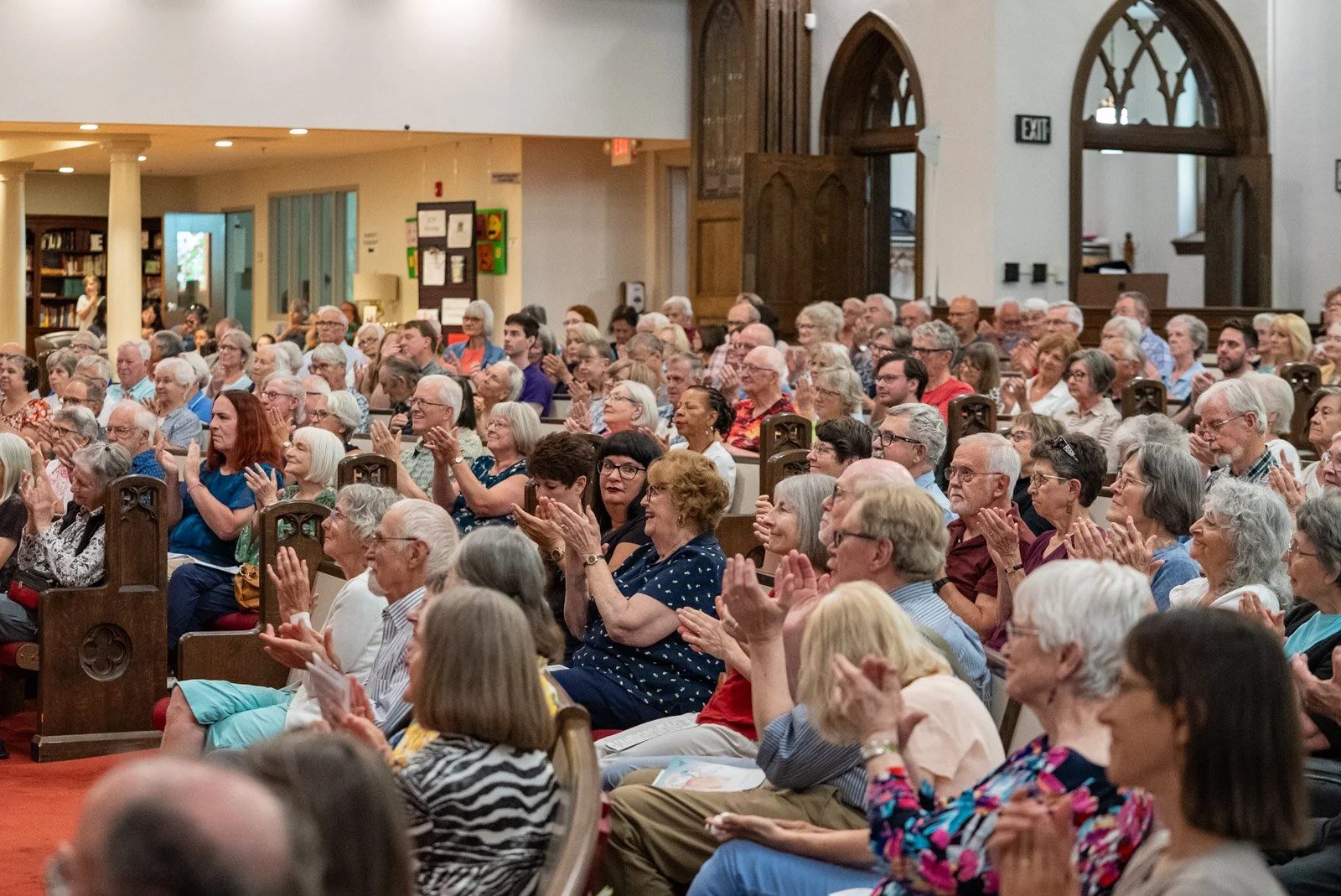 a crowd of people sitting and clapping