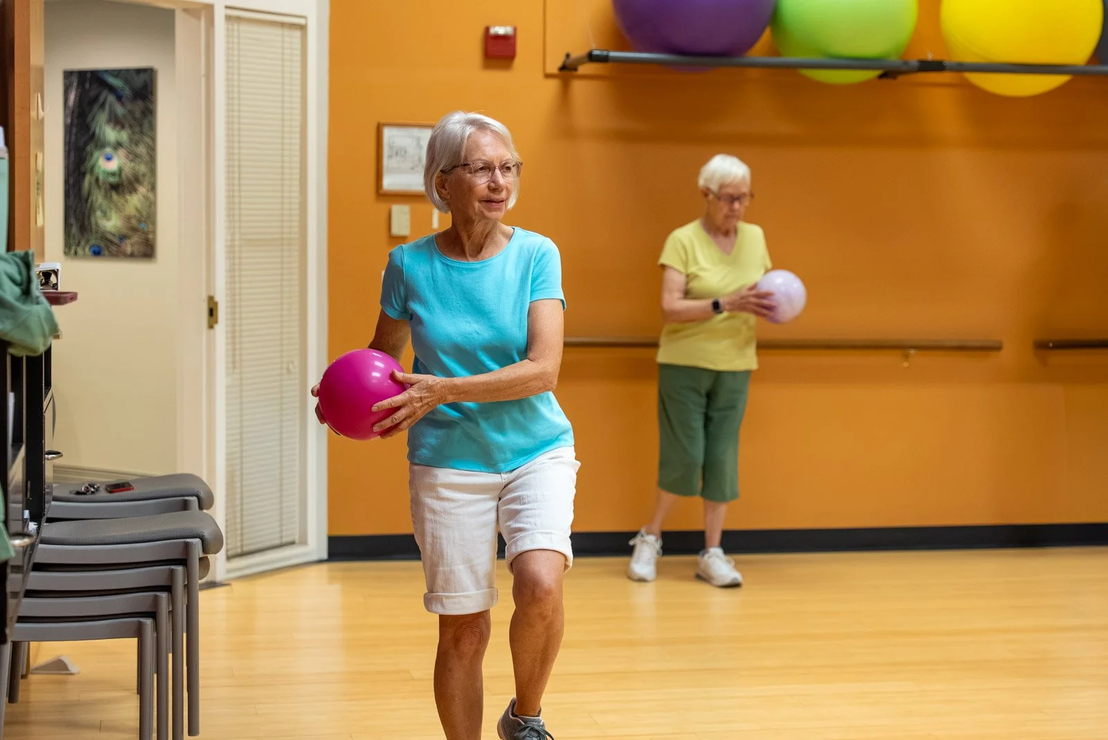 Senior woman tossing a foam ball during a wellness class at VMRC's Harrisonburg Wellness Center.