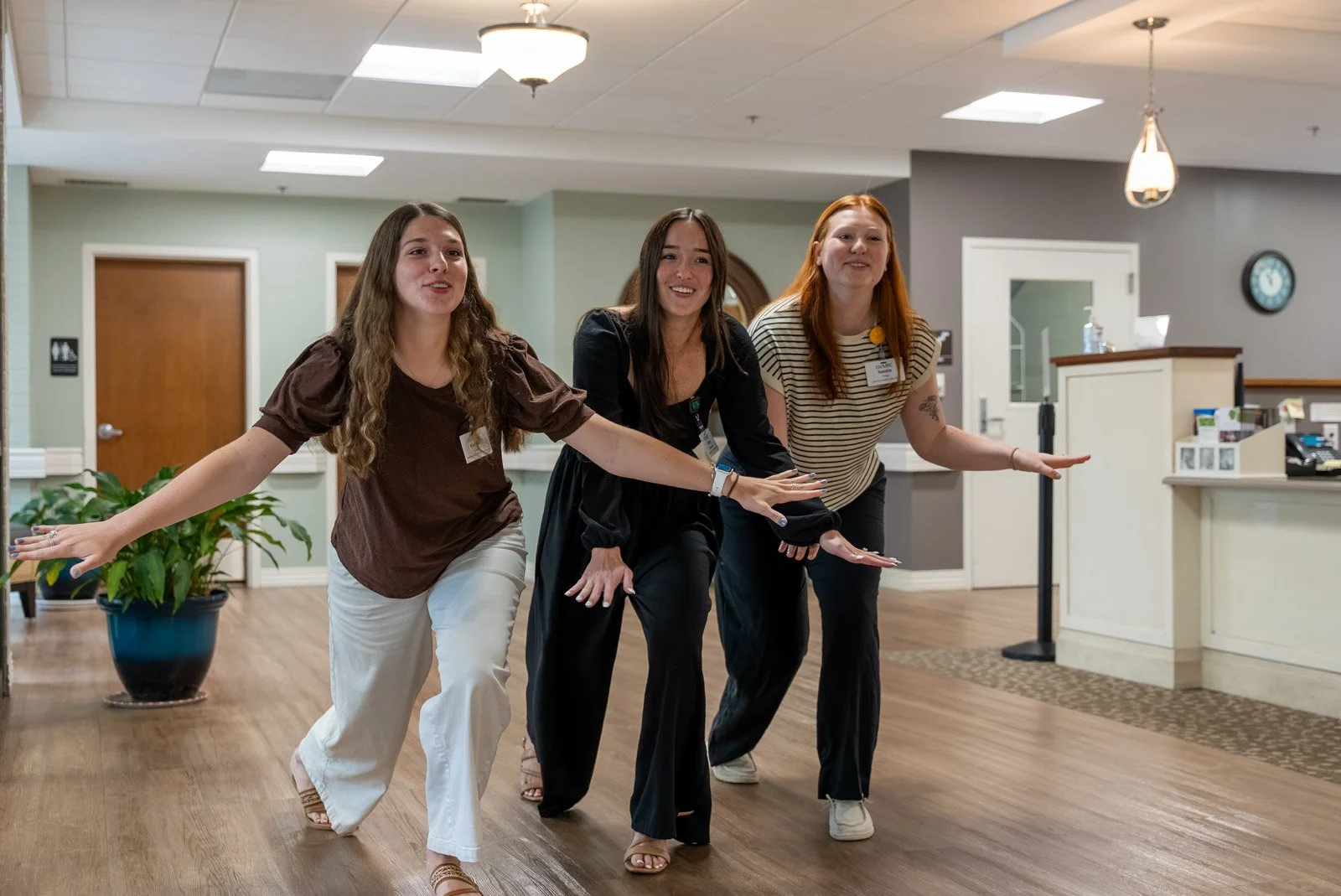 three girls doing the jmu dukes hand motion tradition