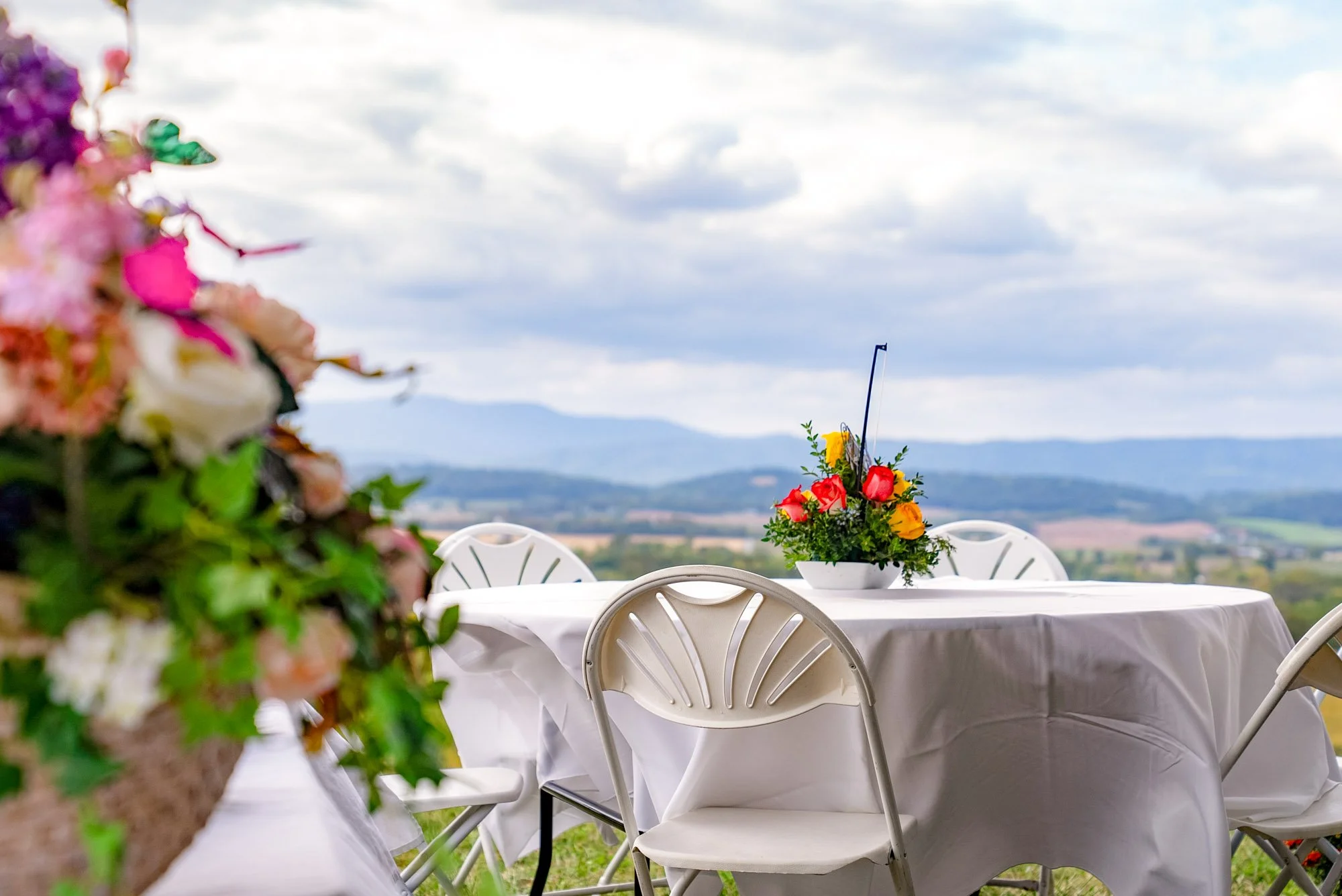 tables set and decorated in an outdoor setting overlooking mountains