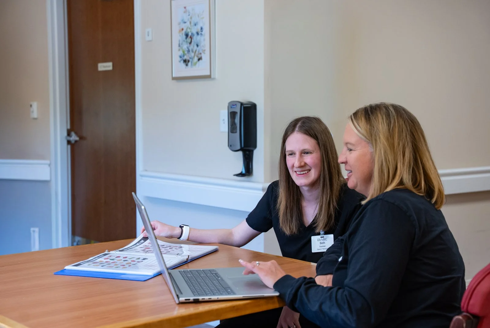 two vmrc care team employees looking at a laptop together.