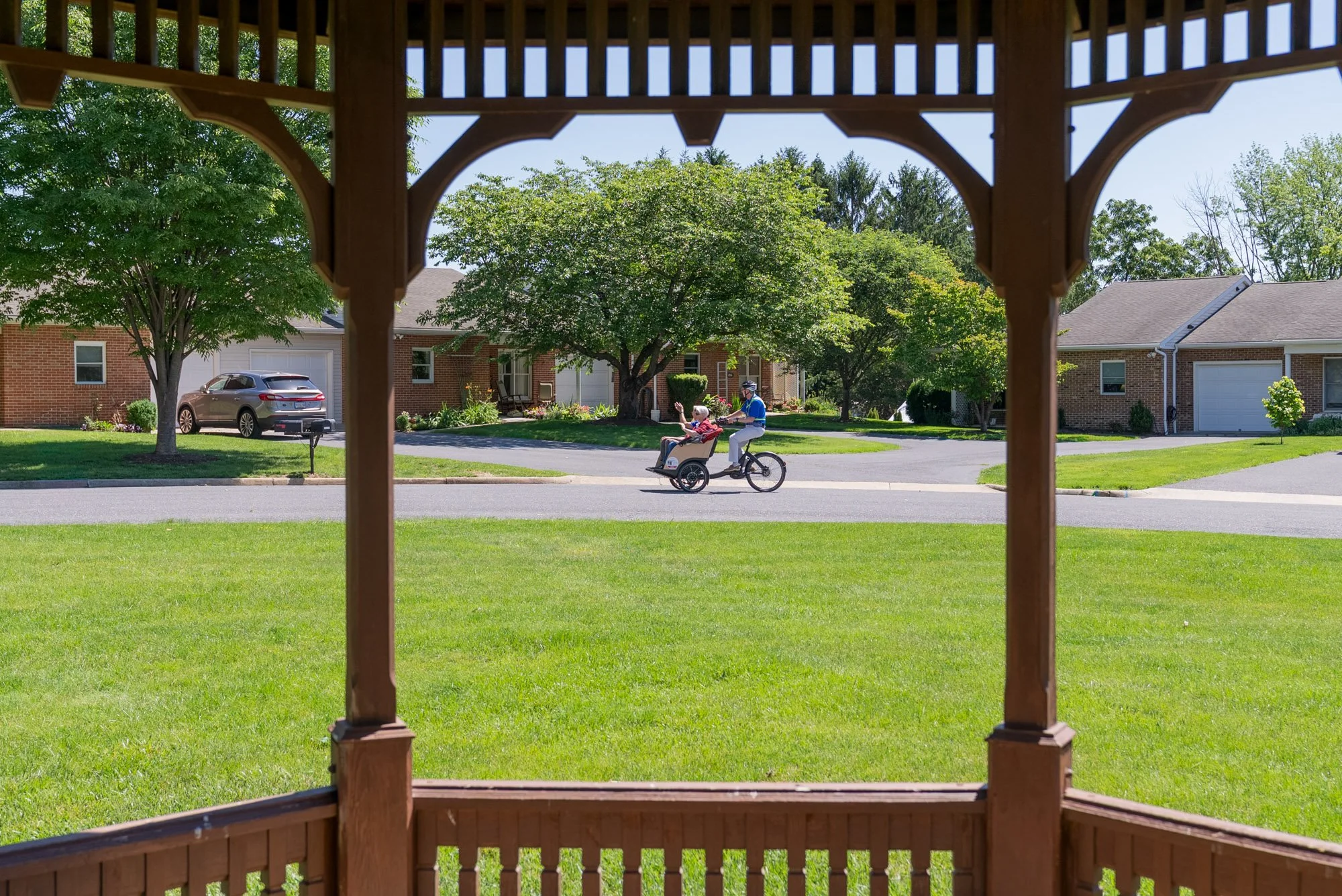 a couple riding in a trishaw framed by the structure of a gazebo