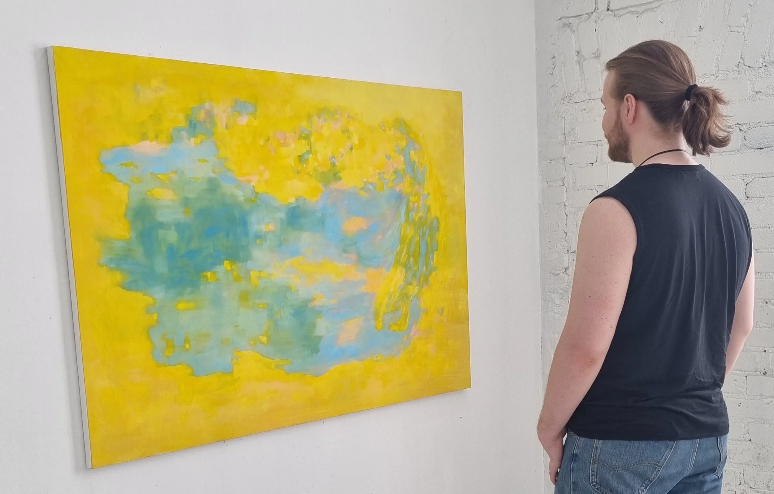 Installation view, Helsinki, 2024. Young man looking at Satu Metsola's large oil painting.