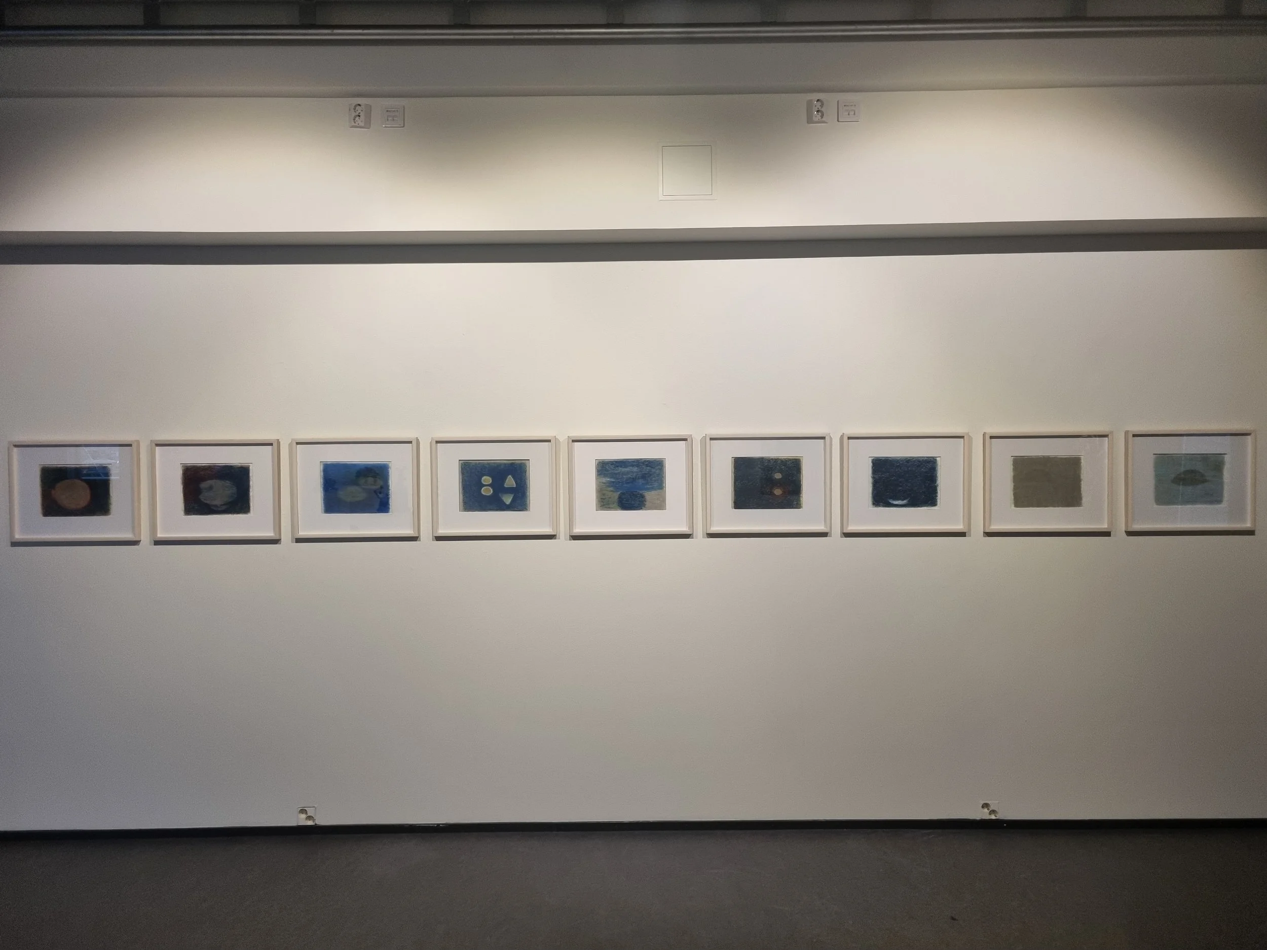 Satu Metsola's artworks, series of oil pastel paintings framed in the gallery