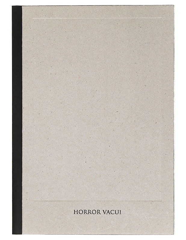 A beige book a black spine and the words "HORROR VACUI" printed at the bottom. Featuring works of Markus Copper, Finnish artist.