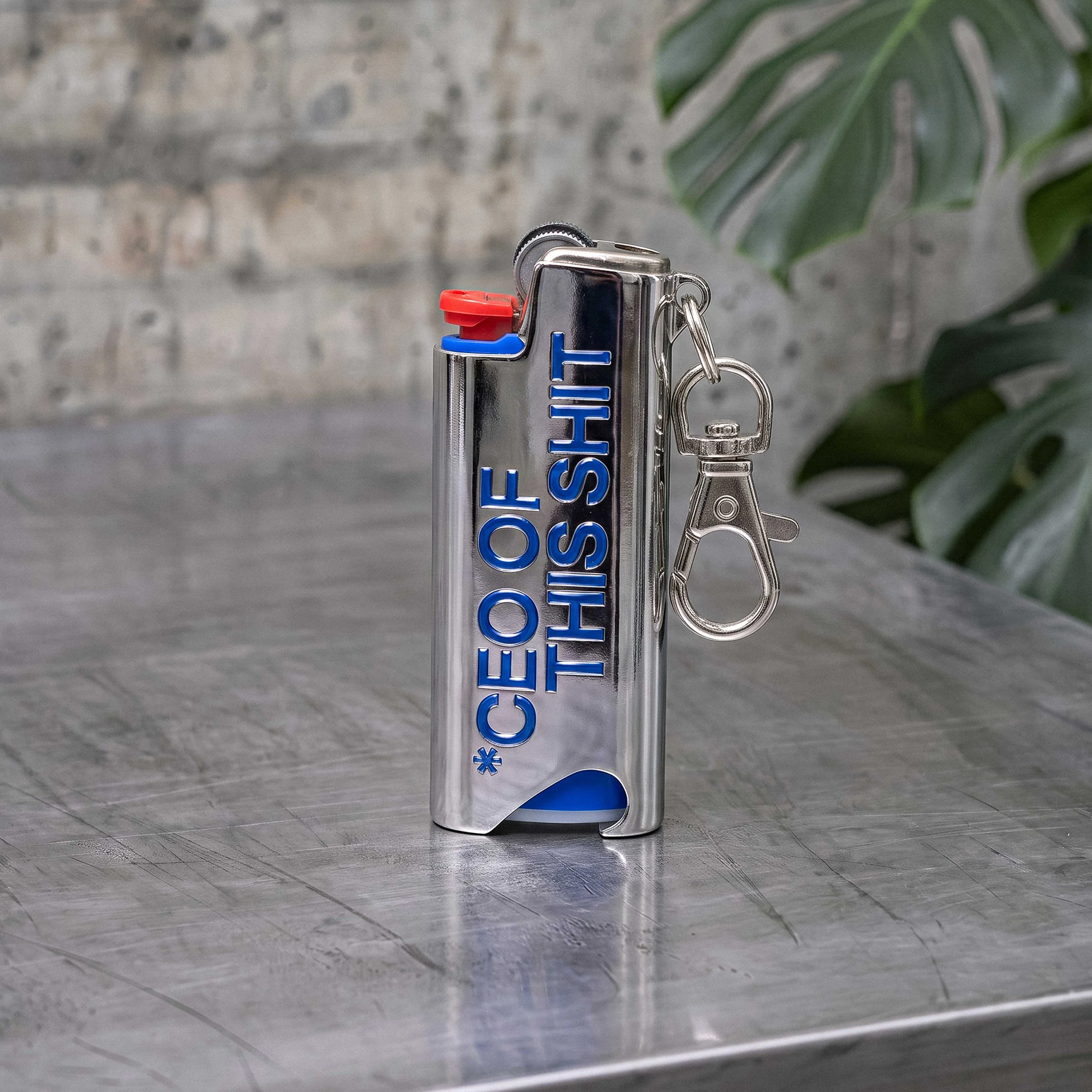 COTS LIGHTER HOLDER cromato con scritta blu CEO OF THIS SHIT, moschettone e apribottiglie integrato