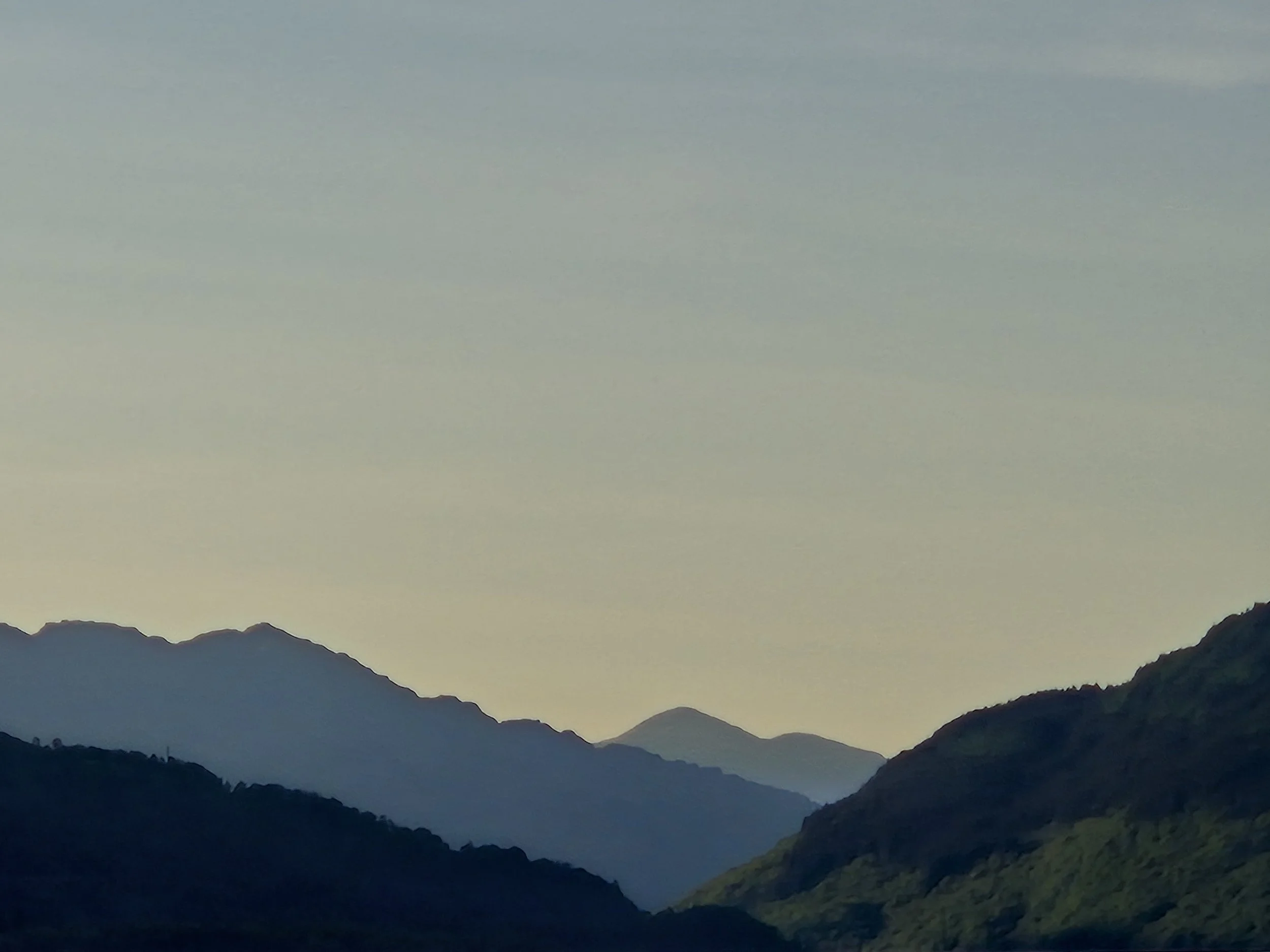 Silhouetted mountains at dusk with a colorful gradient sky.