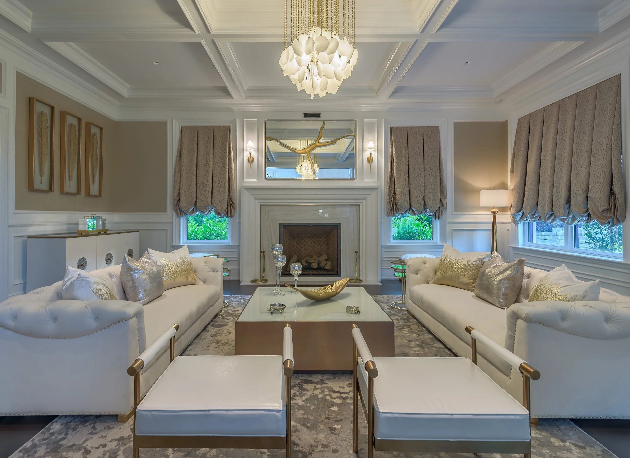 Luxury architectural living room interior with symmetrical seating, coffered ceiling, custom chandelier, and refined residential design details.