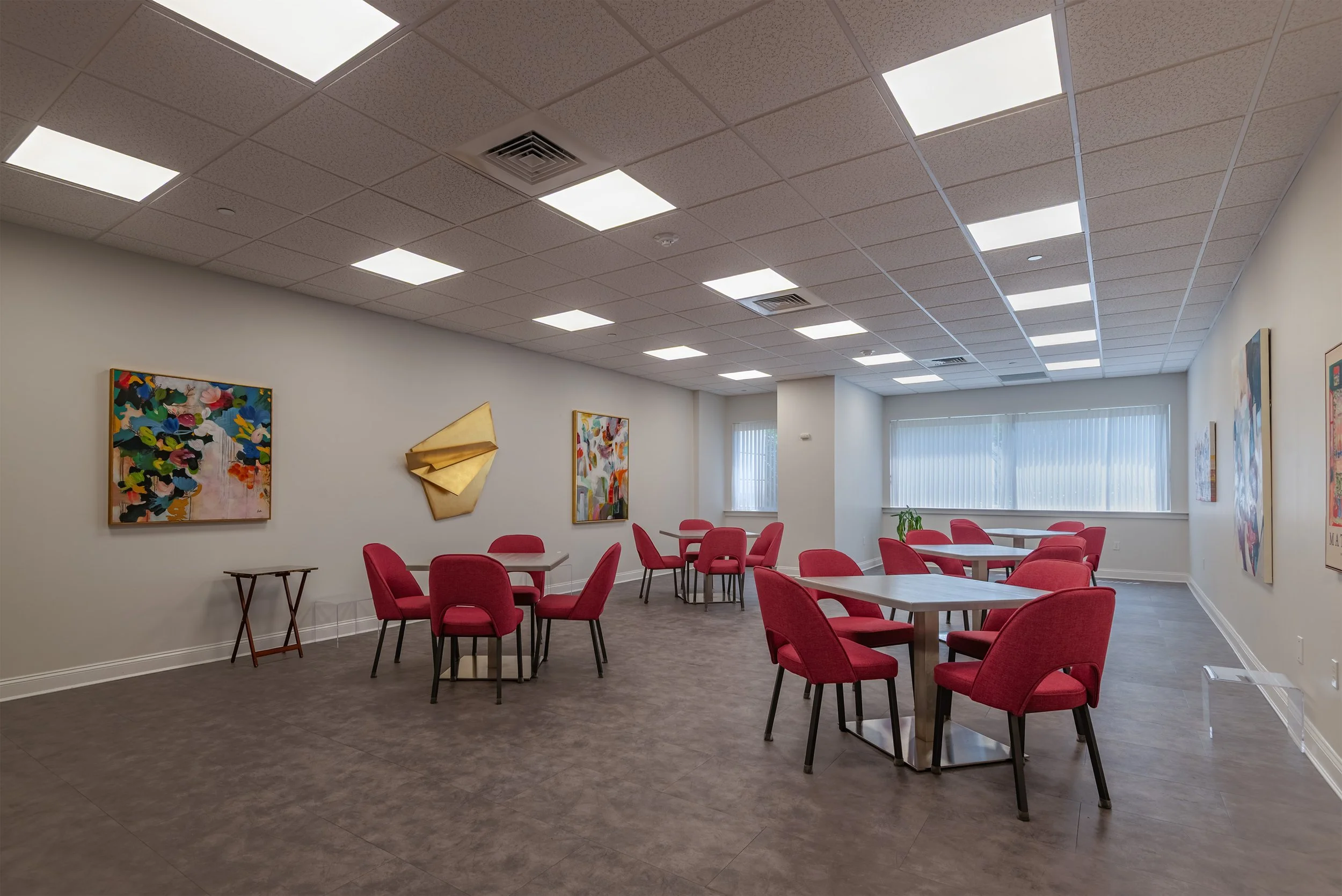 Modern community lounge with seating and artwork inside The Addison senior living community in Port Washington, NY.