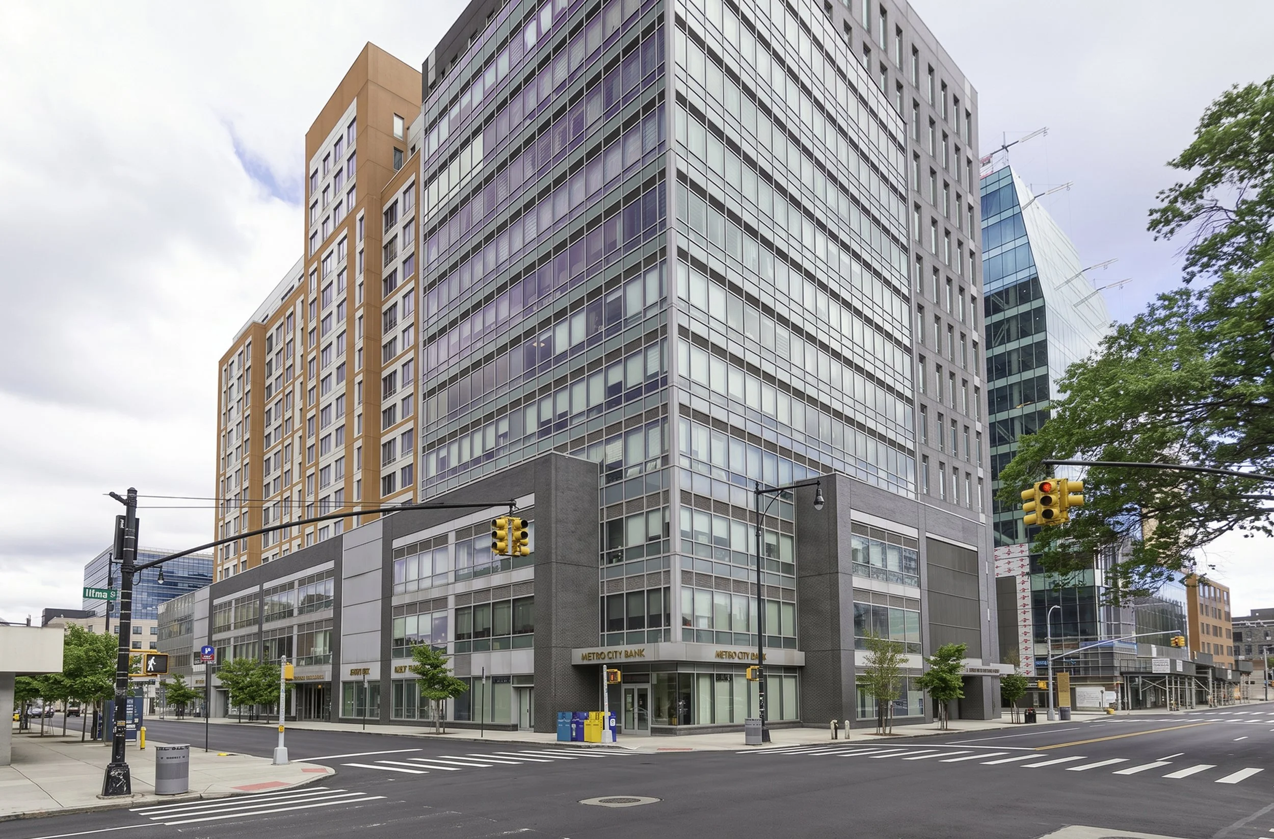 Commercial architecture photography of a modern mixed-use office and retail building featuring glass curtain wall construction in an urban environment.