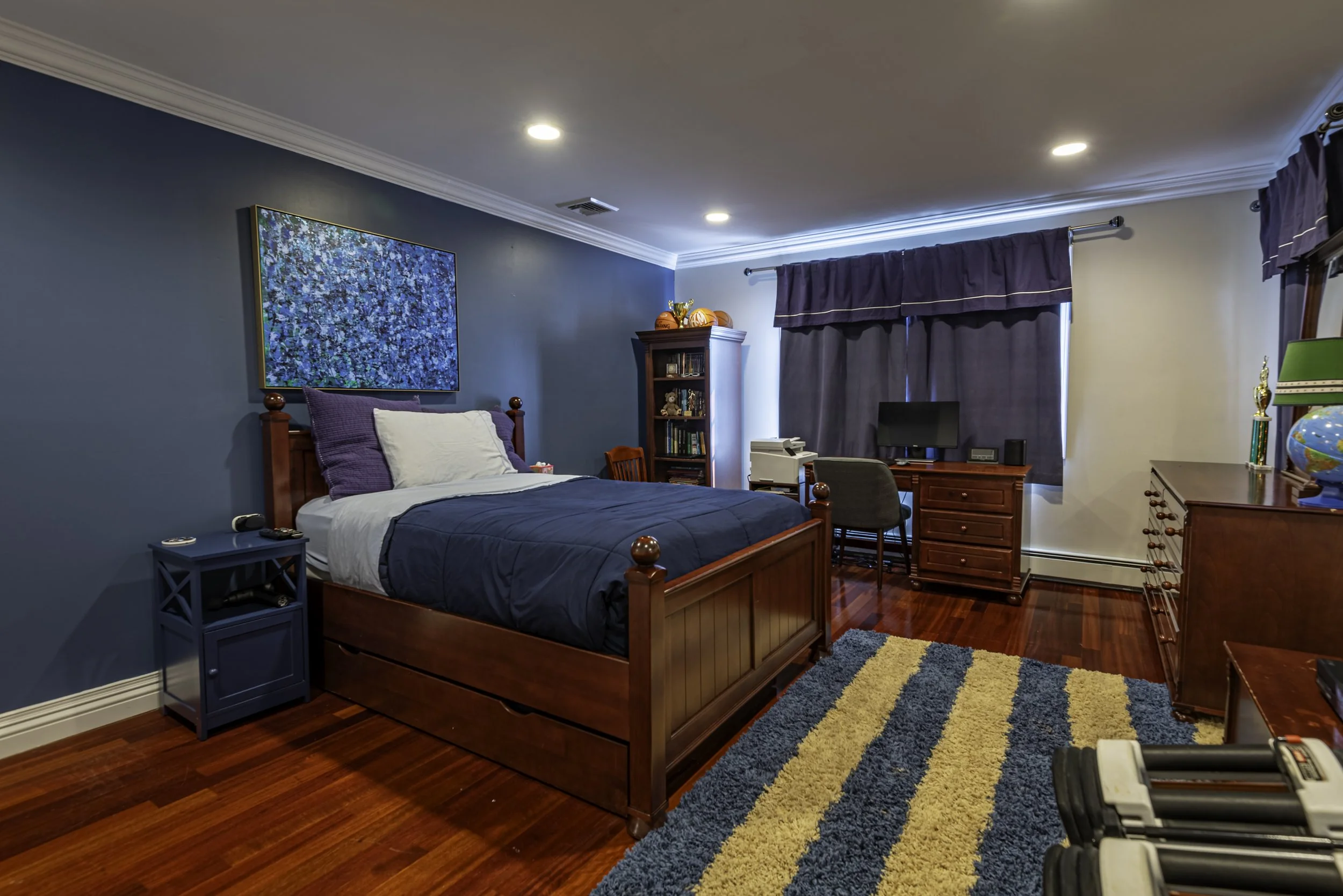 Bright modern bedroom with vaulted ceiling, skylight, bunk bed, hardwood floors, and built-in storage captured by a professional real estate photographer in New York.