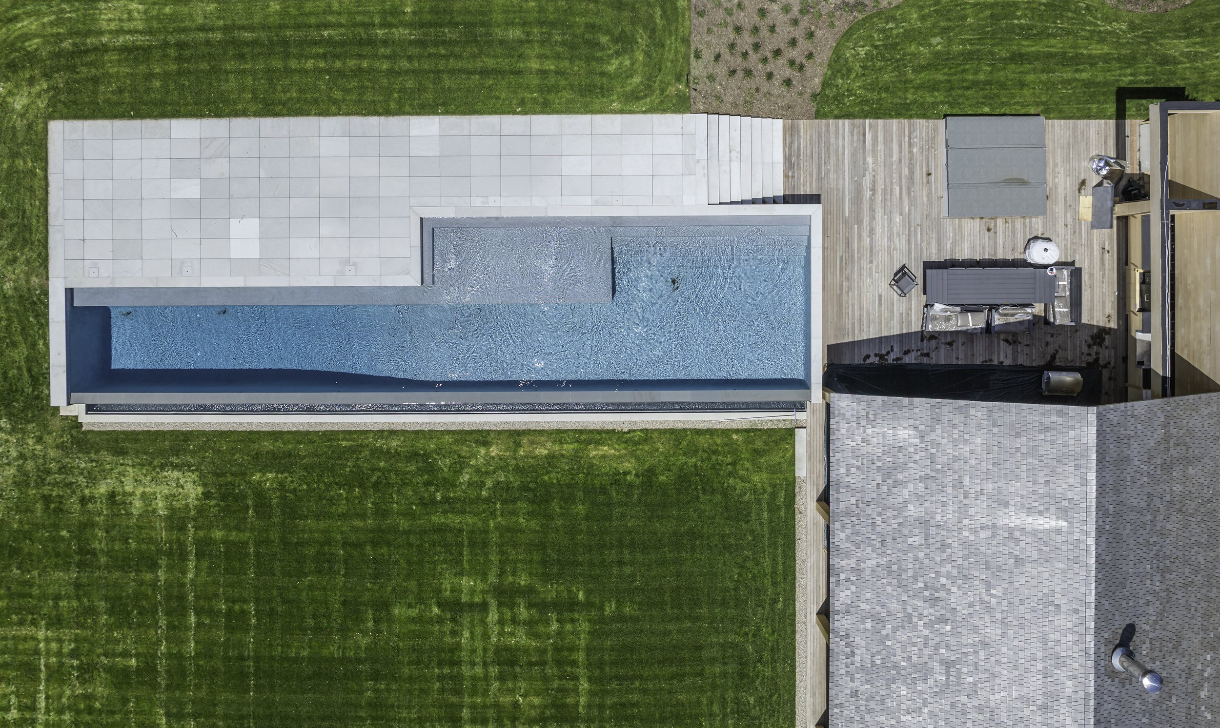 Modern pool house, swimming pool, and landscaped lawn photographed during residential project documentation.