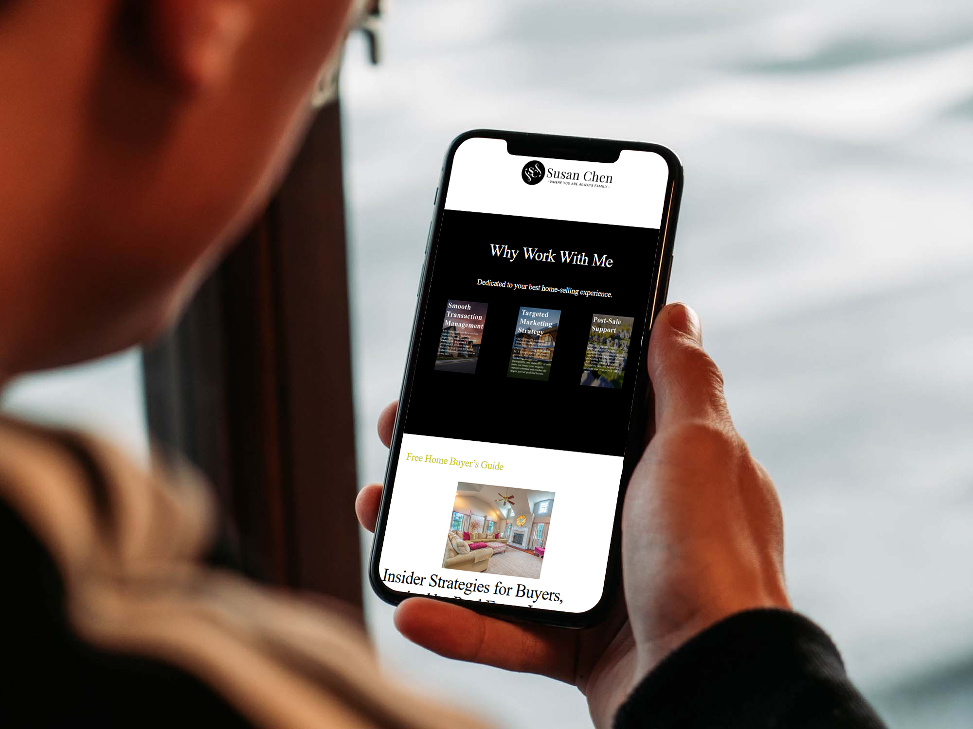 Person holding an iPhone displaying a real estate agent website with a ‘Why Work With Me’ section and buyer resources.”