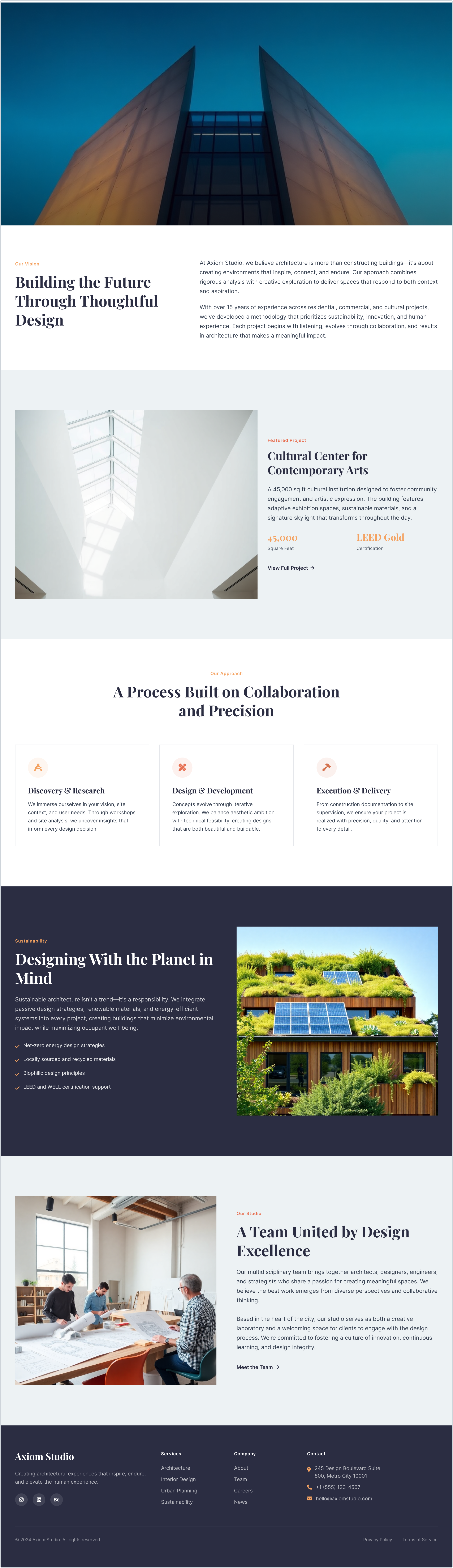 A modern building with a tall, angled facade viewed from below, with a clear blue sky in the background.