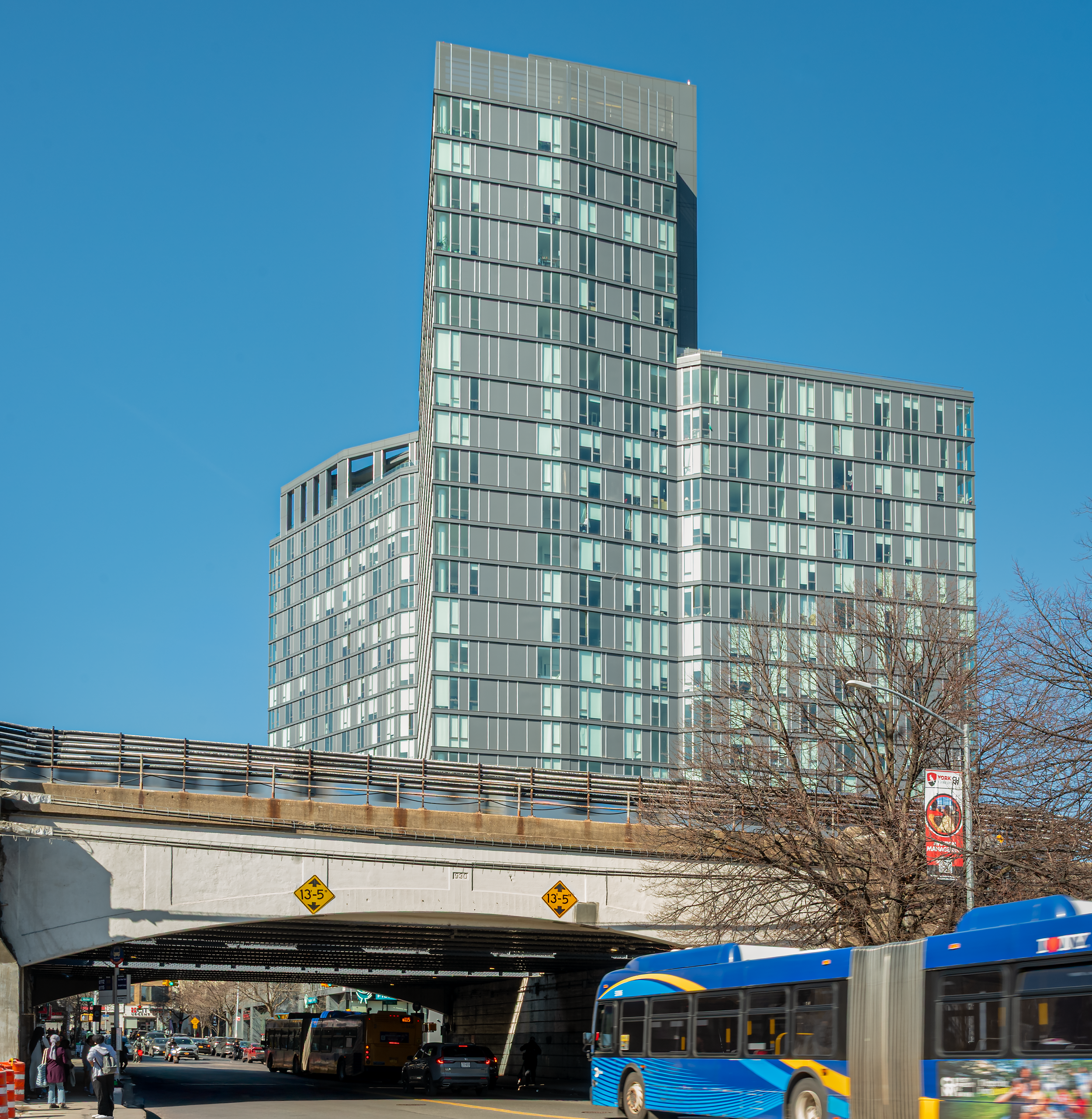 Archer Tower 1 residential high-rise in Jamaica, Queens NYC with elevated train tracks and city street view
