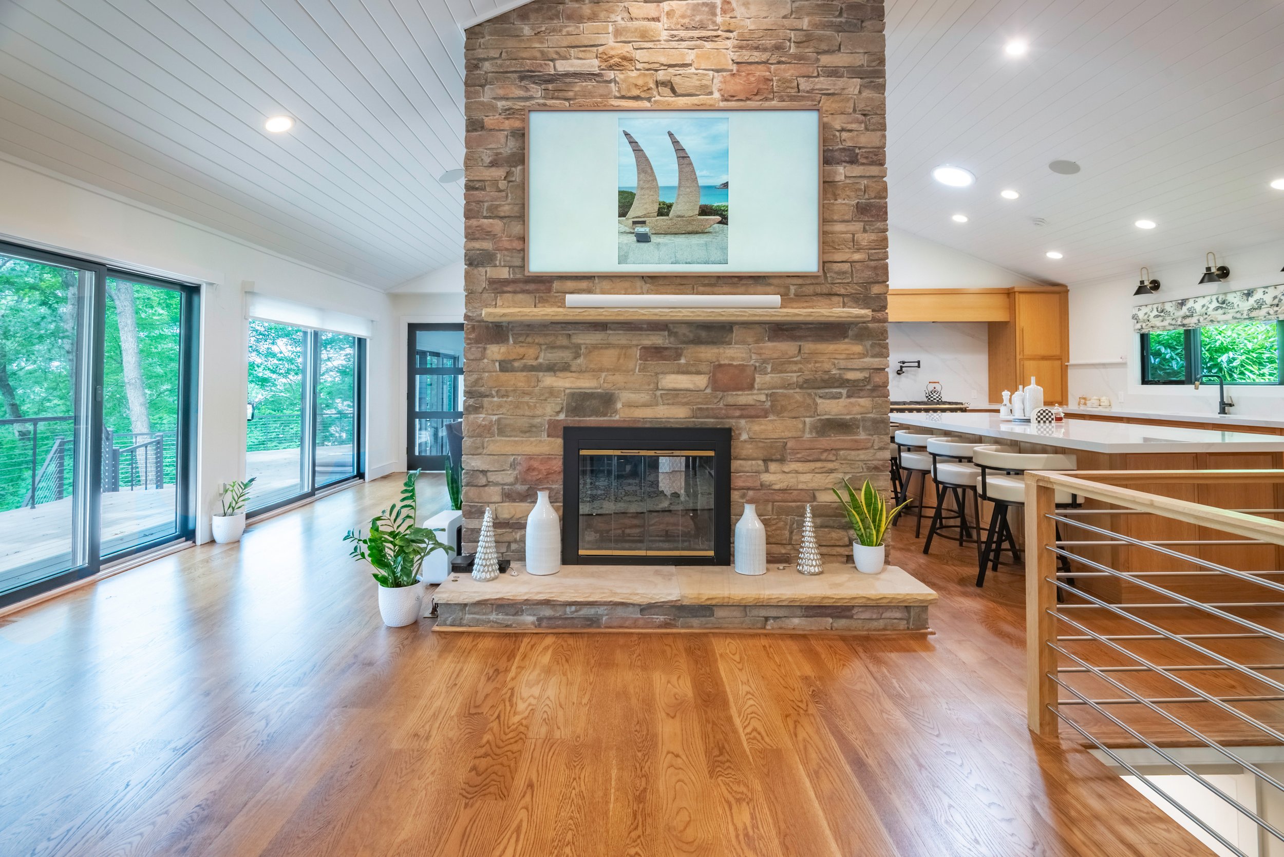 open concept living room with floor-to-ceiling stone fireplace, white oak hardwood floors, and kitchen island — Port Jefferson, NY | Palma Design