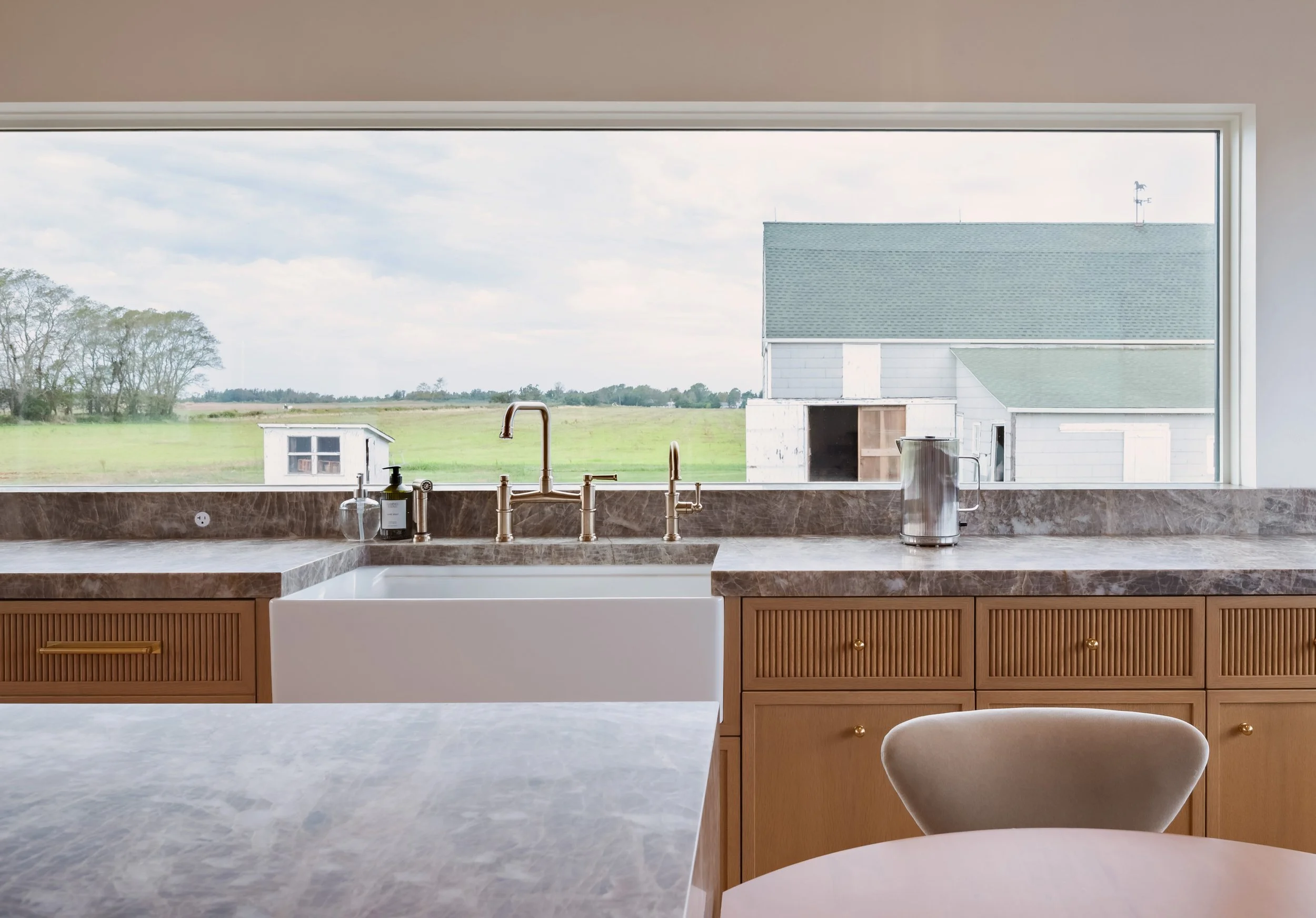 04-north-fork-gut-renovation-farmhouse-sink-picture-window-barn-view.jpg