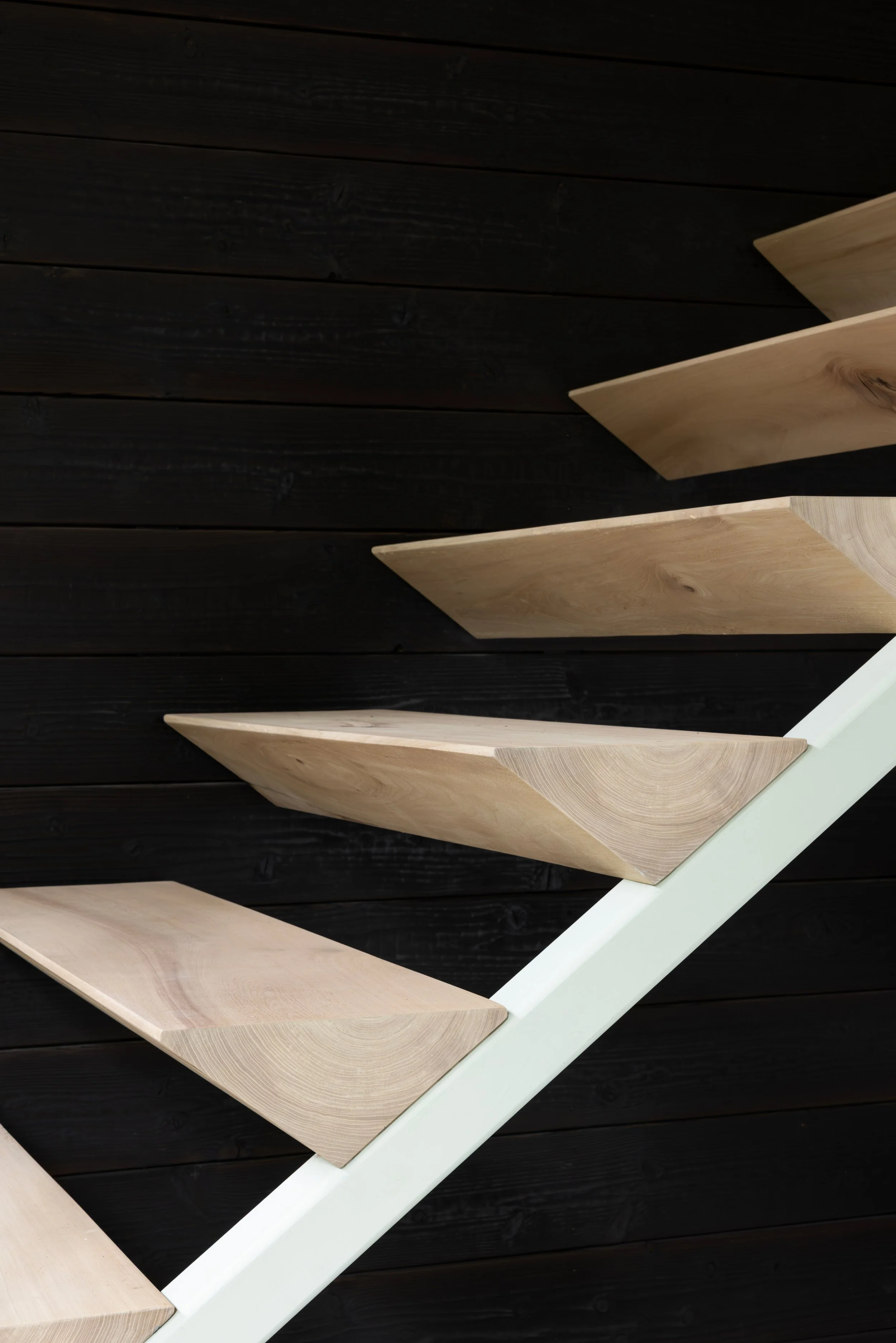 Close-up of wooden stairs with black wooden wall background.