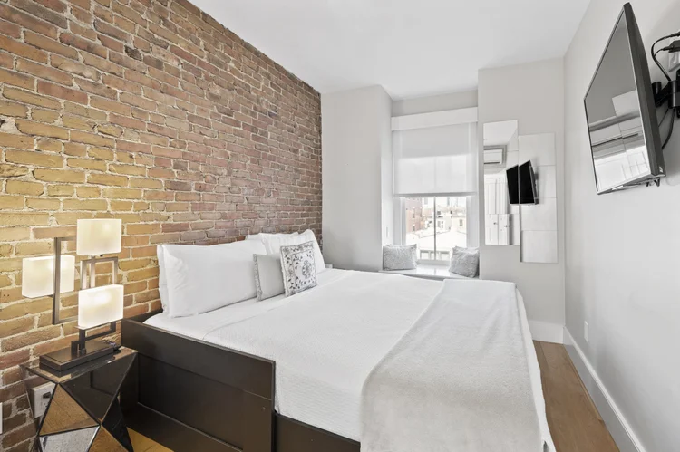 Guest bedroom with exposed brick wall