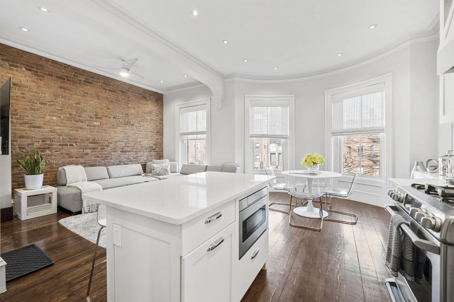 Open kitchen and living space with exposed brick in the Brownstone unit