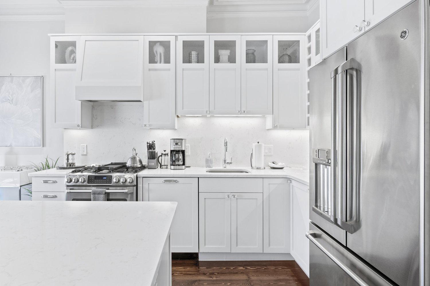 White kitchen with quartz counters and stainless appliances