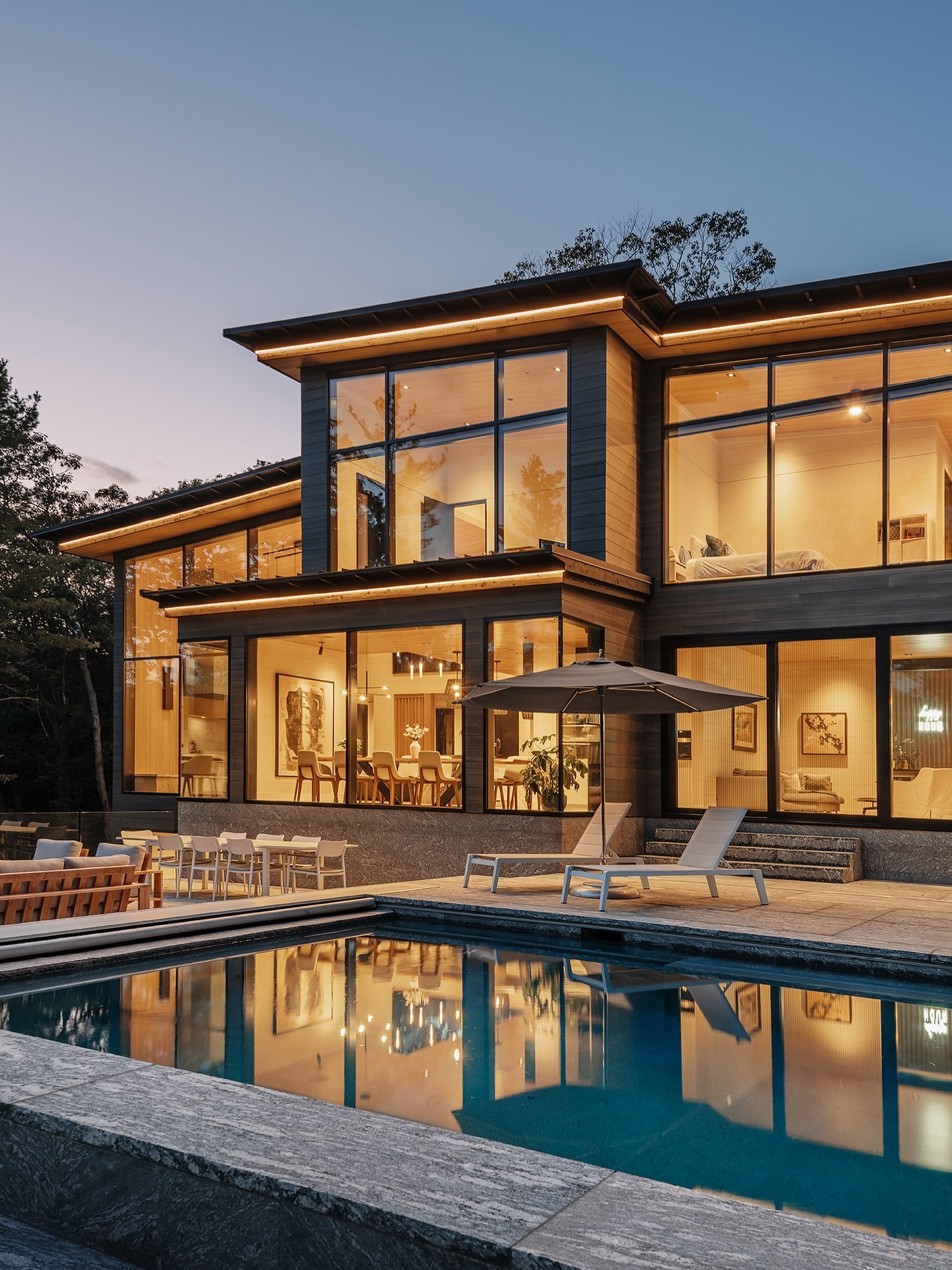 Happy Hour. 

Each side of Darkwood is equally impressive in the twilight.

MATERIALS
&bull; Custom Windows &amp; Doors by Muskoka Lumber
&bull; Soffit: 1x8 Clear Hemlock, 1/8&rdquo; Gap, Smooth Face, Custom Finish
&bull; Siding: 1x8 Clear Heat Treat