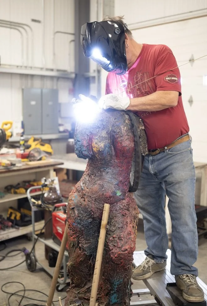 Man welding a female figure statue