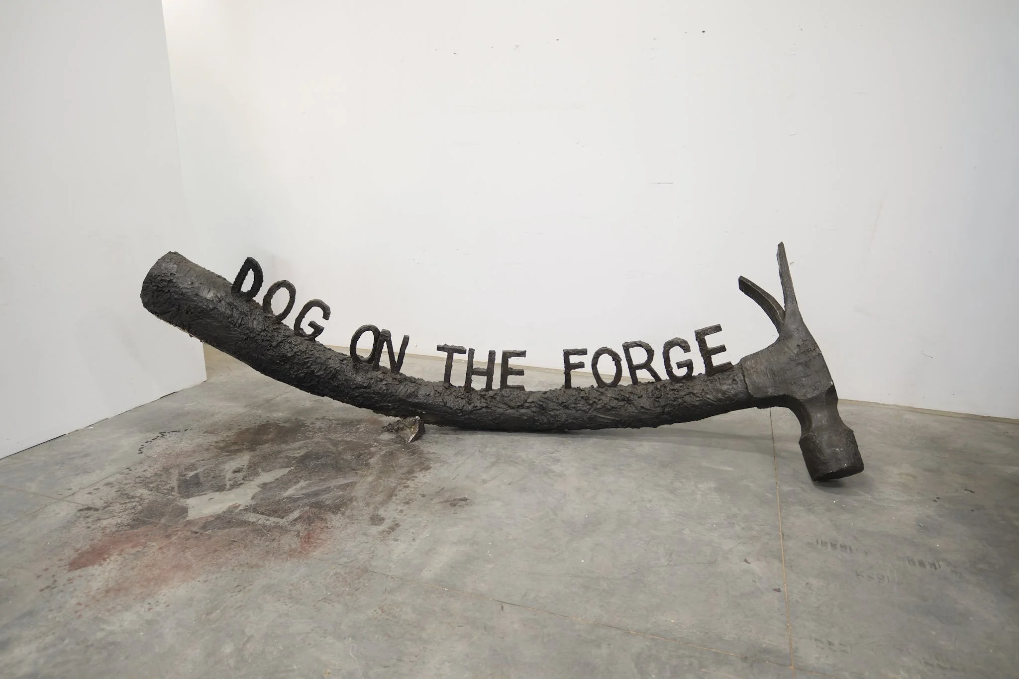 Metal Hammer sculpture with "dog on the forge" written on top.