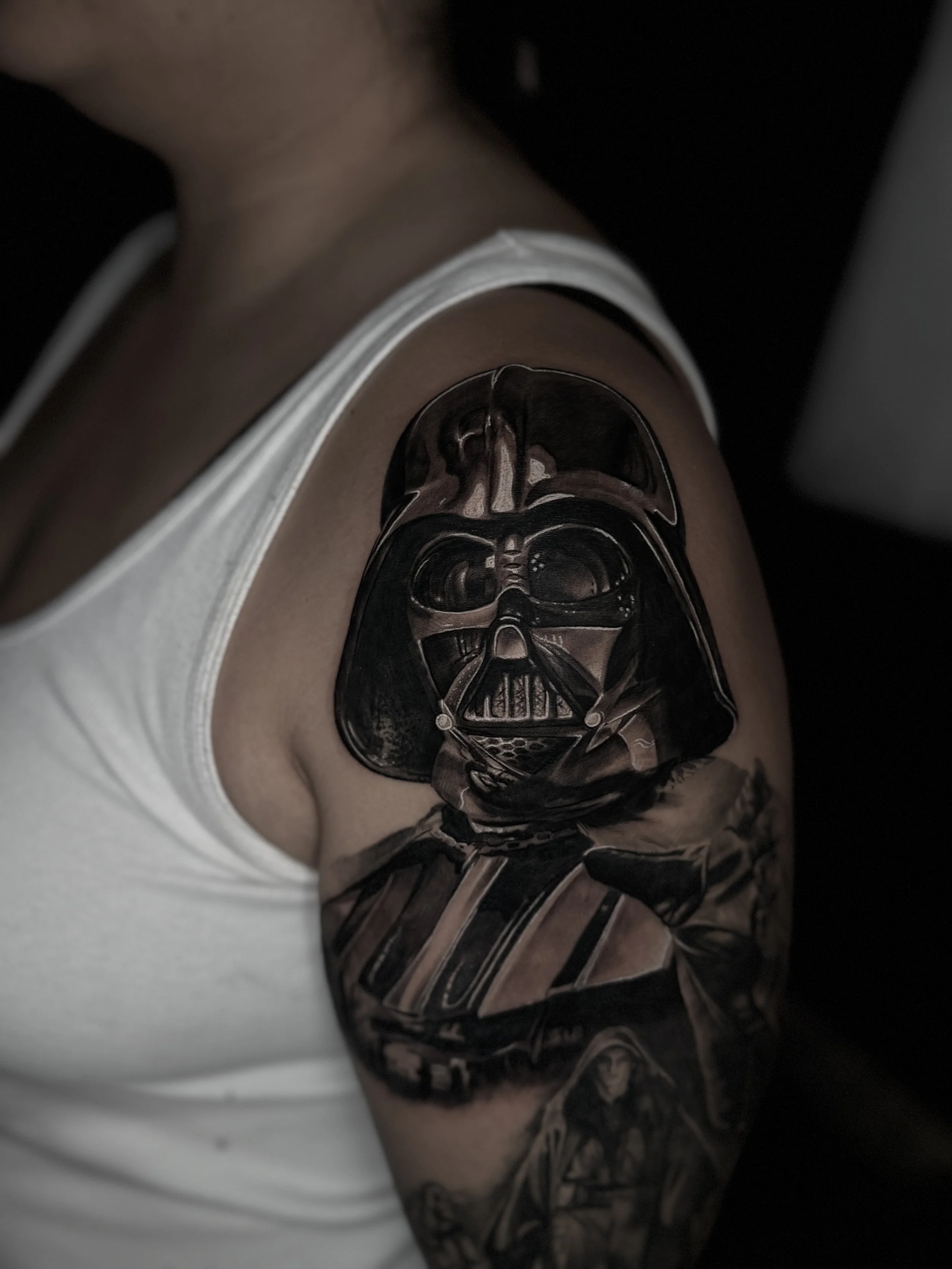 Tattoo of Darth Vader's helmet on a person's upper arm done by Richy Reynolds at Harp and Rose Tattoo in Ventura California