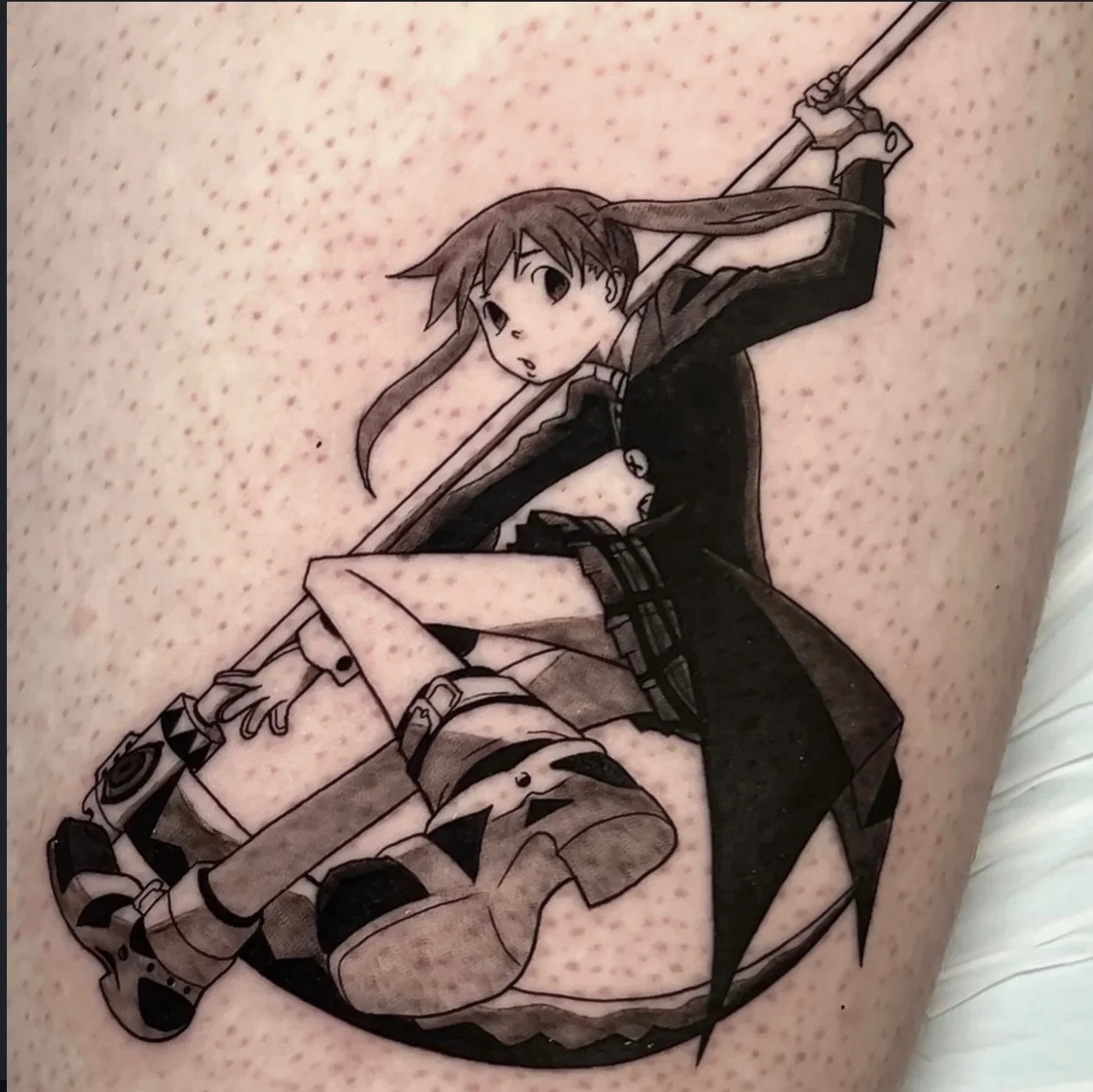 Black and white tattoo of Soul Eater anime character with long hair, holding a spear, and a small animal-like creature near her feet by Mando at Harp and Rose Tattoo in Ventura California