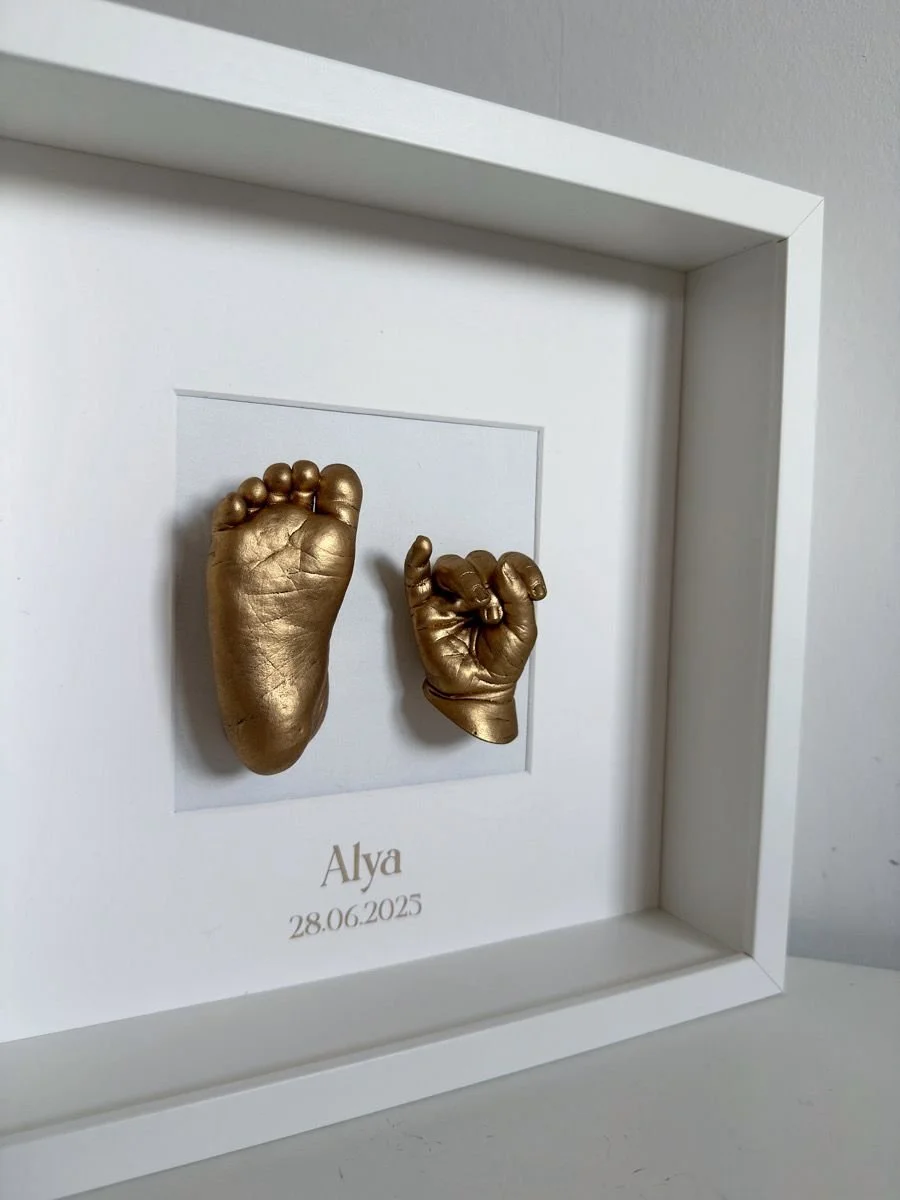 Gouden baby hand en voetafdruk in witte kader