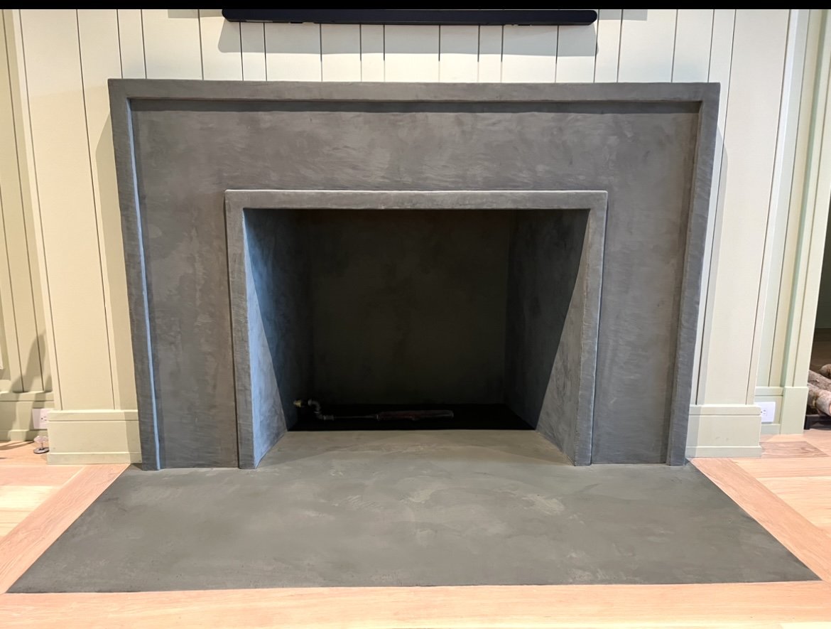Modern minimalist concrete fireplace with grey finish and clean lines