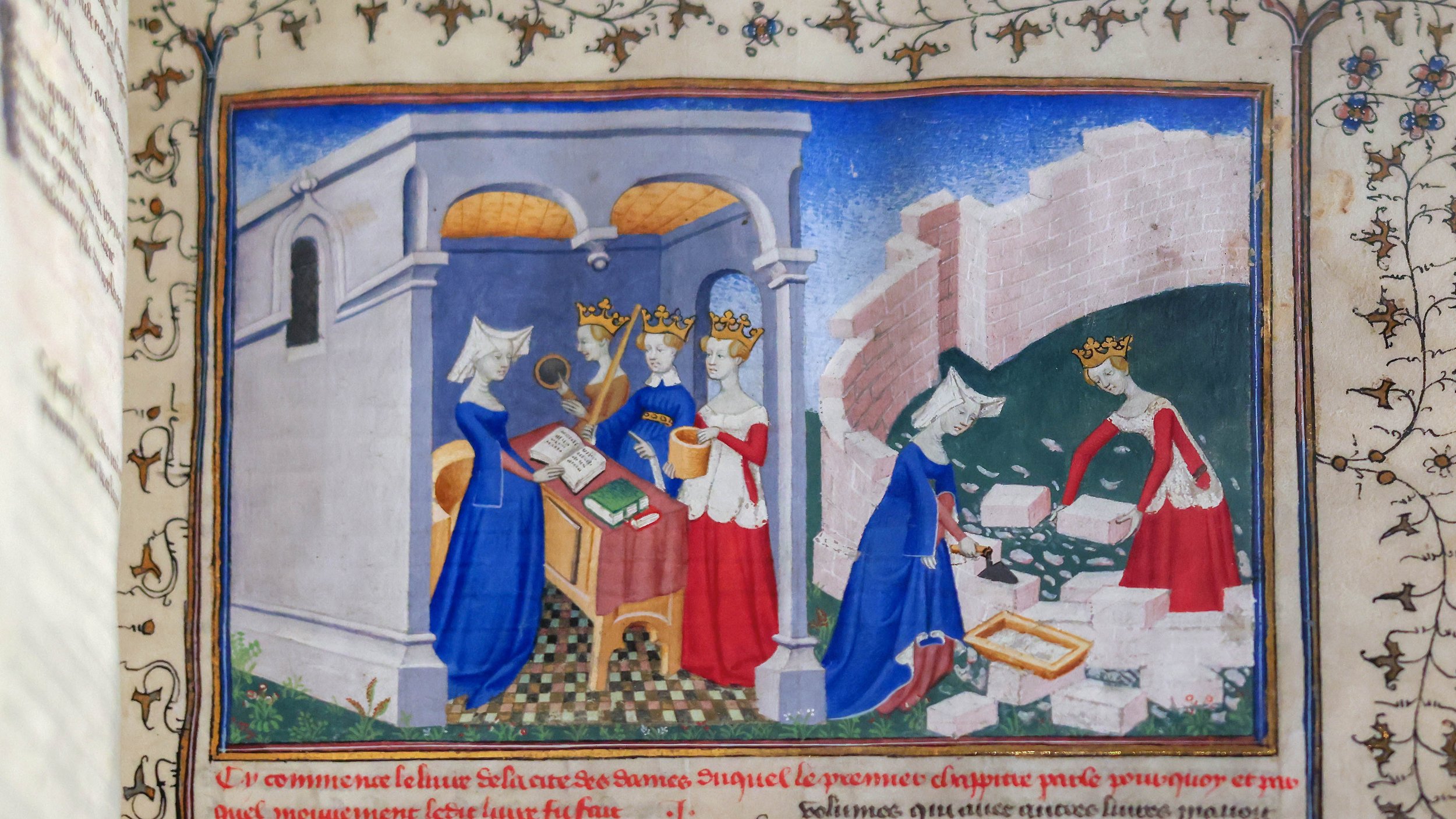 A medieval illuminated manuscript illustration depicting crowned women, two in red and two in blue. One woman in blue is exchanging a book, while another cuts and shapes bricks outside a brick wall.