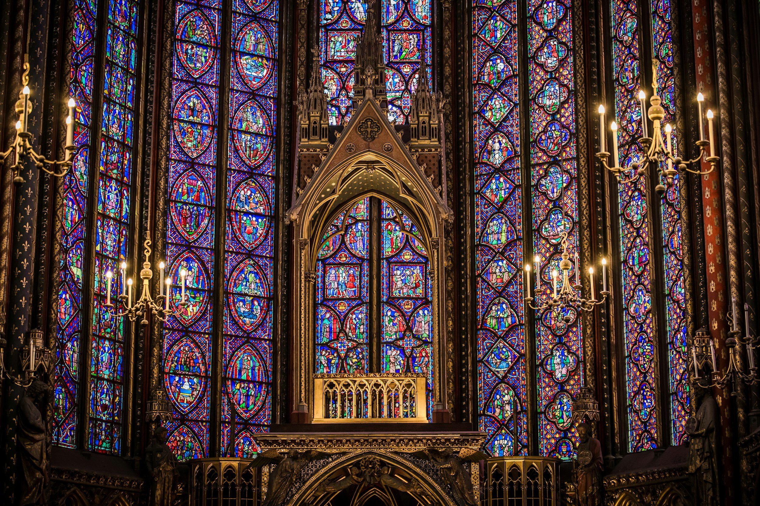 stained glass windows in a space lit by candles