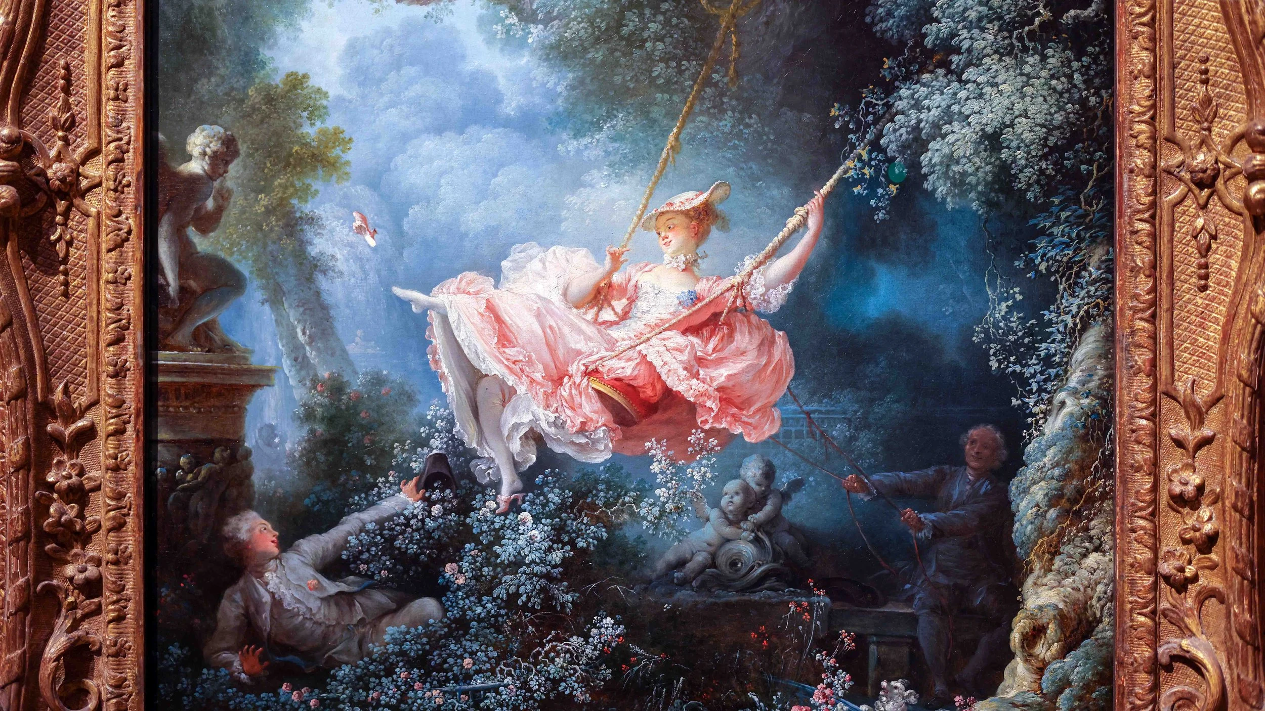 A classical painting of a young woman in a pink dress on a swing, surrounded by a lush garden scene, with a man on the right holding the swing ropes and a young boy on the left reaching up. The painting features ornate gold framing.