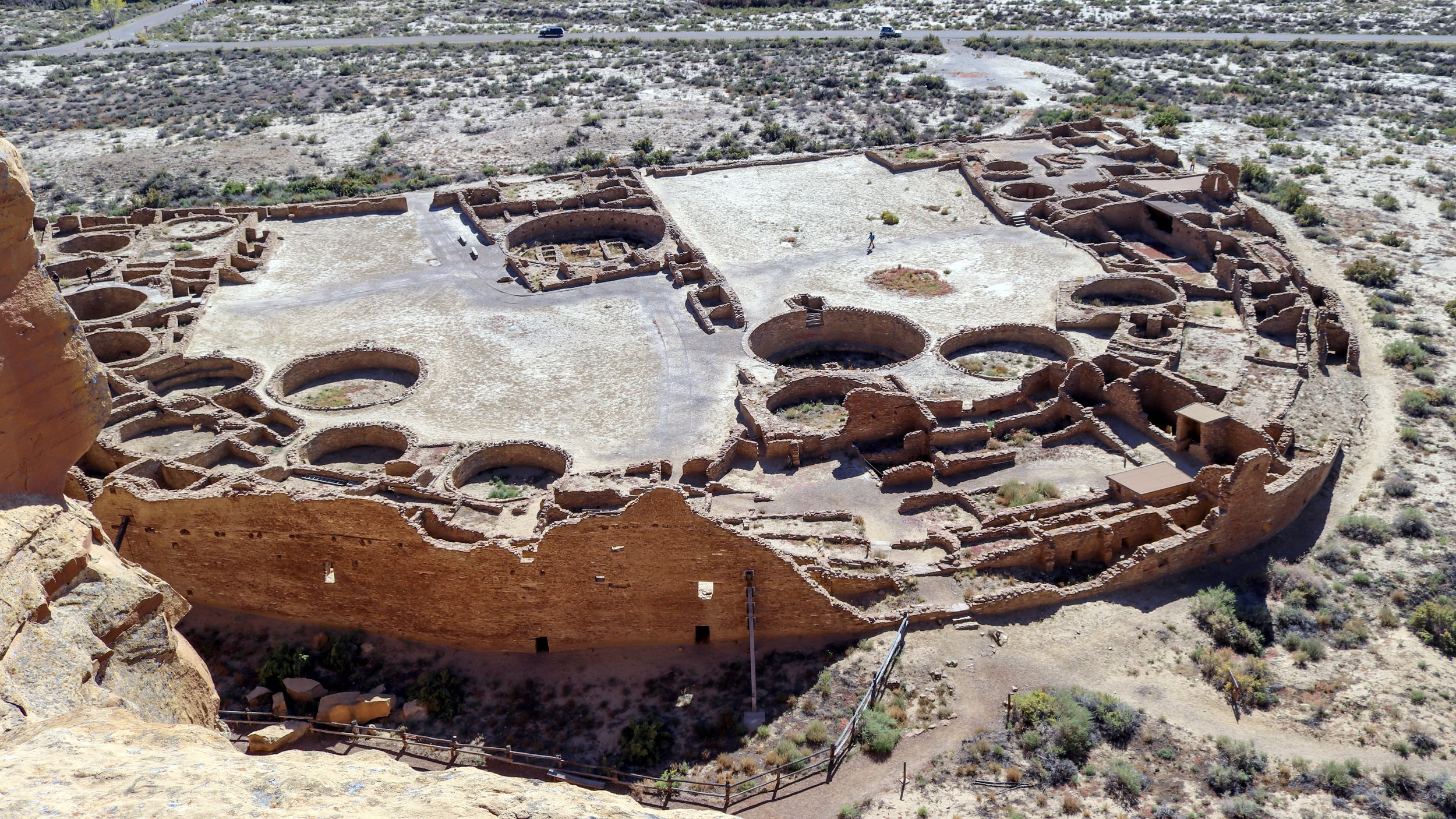 a large d-shaped building is seen from above on a mesa