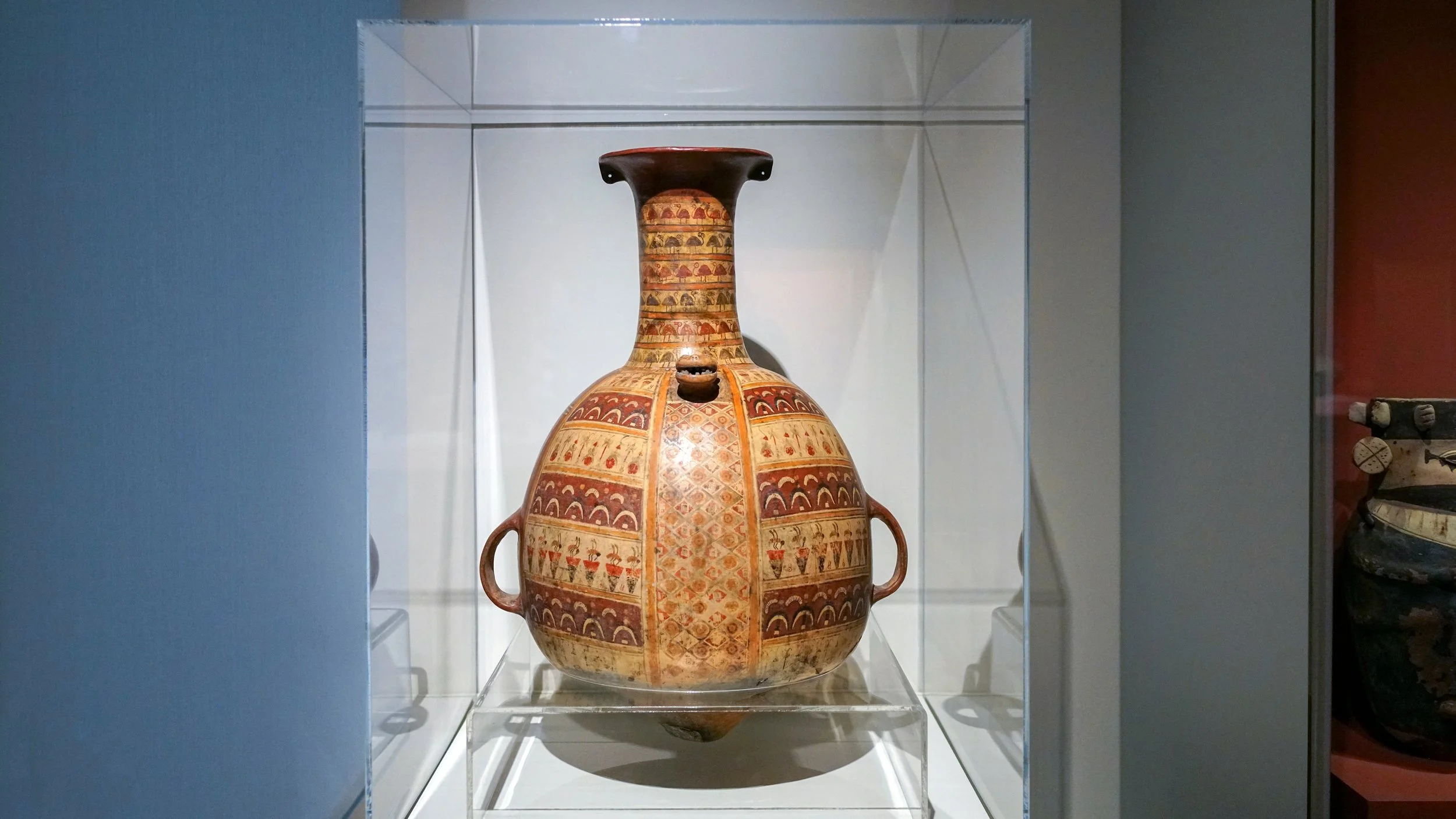 A vessel is covered in designs and has a pointed base