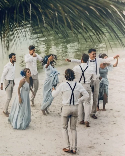 Les invités d'un mariage dansent au bord de l'eau