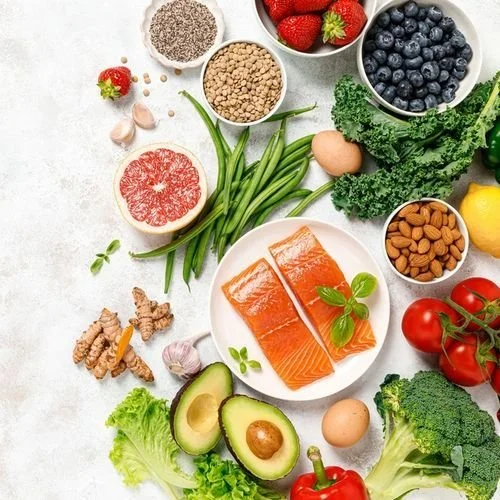 Longevity foods including salmon, berries, greens, nuts, and avocado