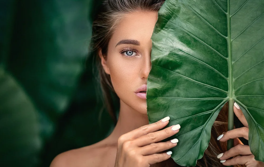 Woman with radiant skin framed by a green leaf, graceful aging and skin care in Brandon, FL