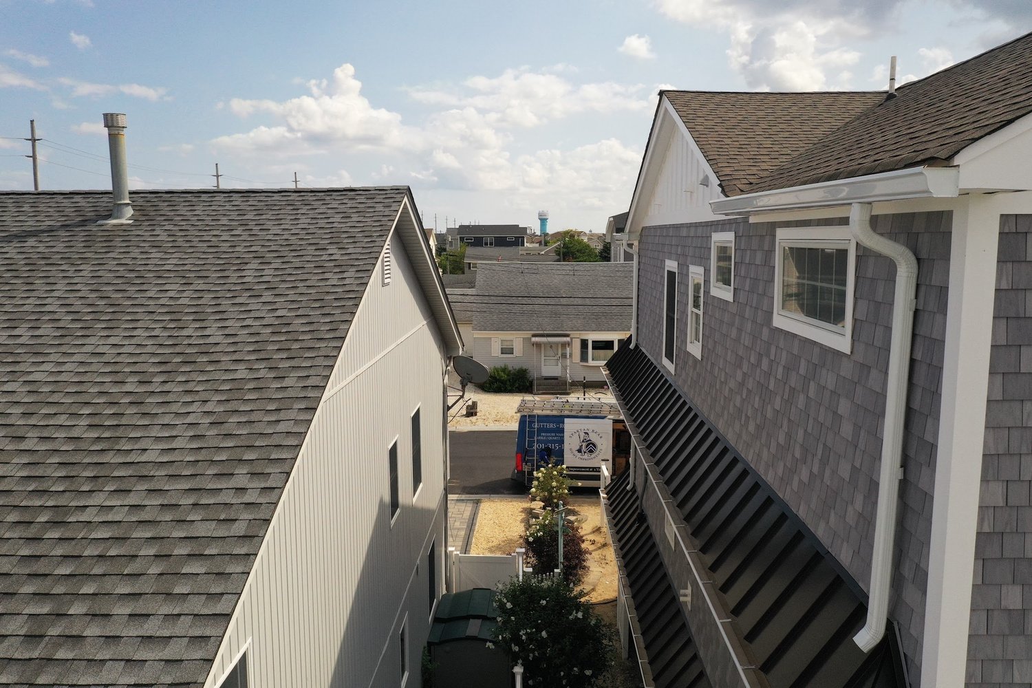 White K-style gutters and elbow-connected downspouts on a gray-sided home, from Spartan Bear's project gallery
