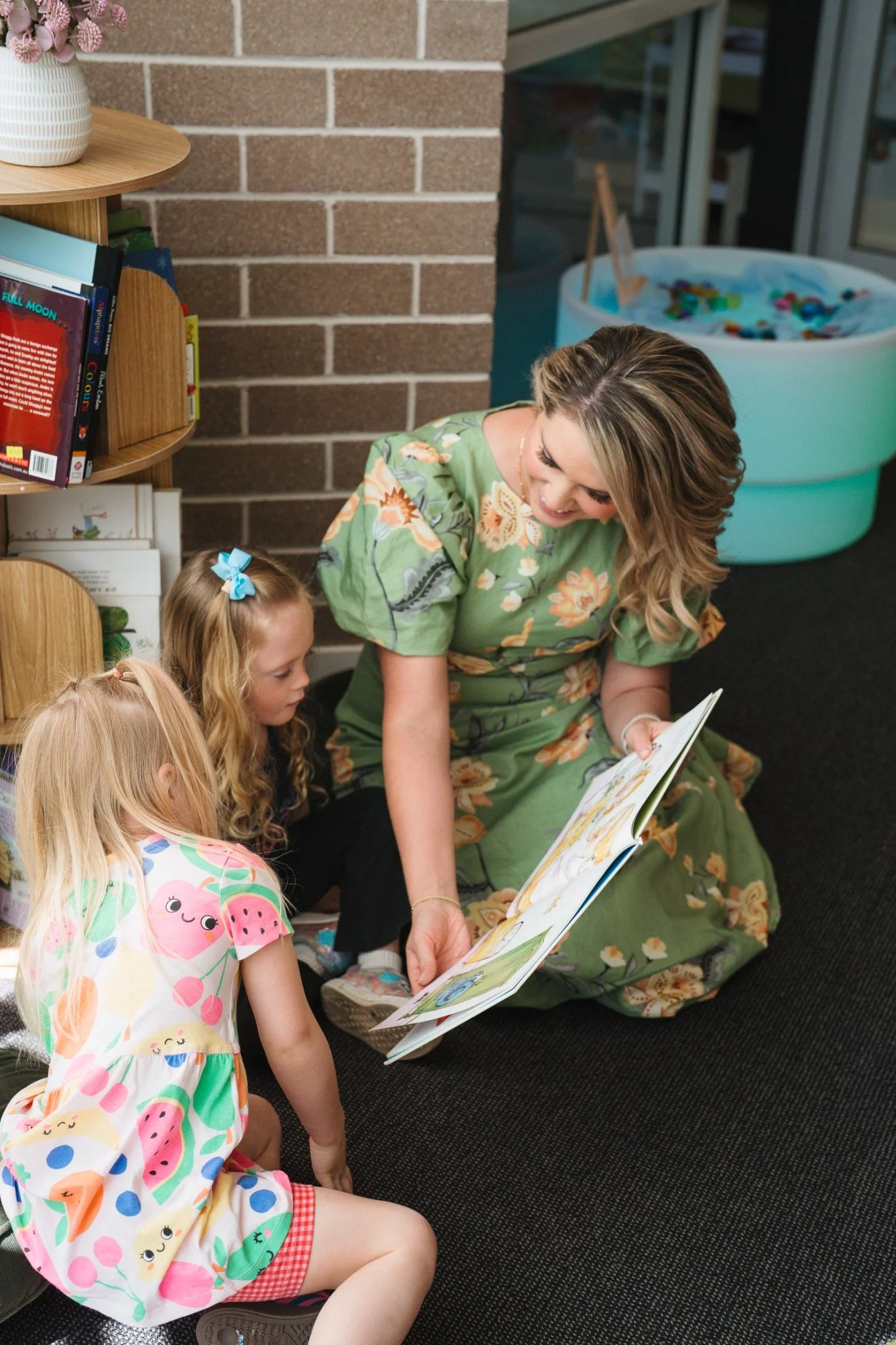 Brooke reading with two children in the Prep For School learning space